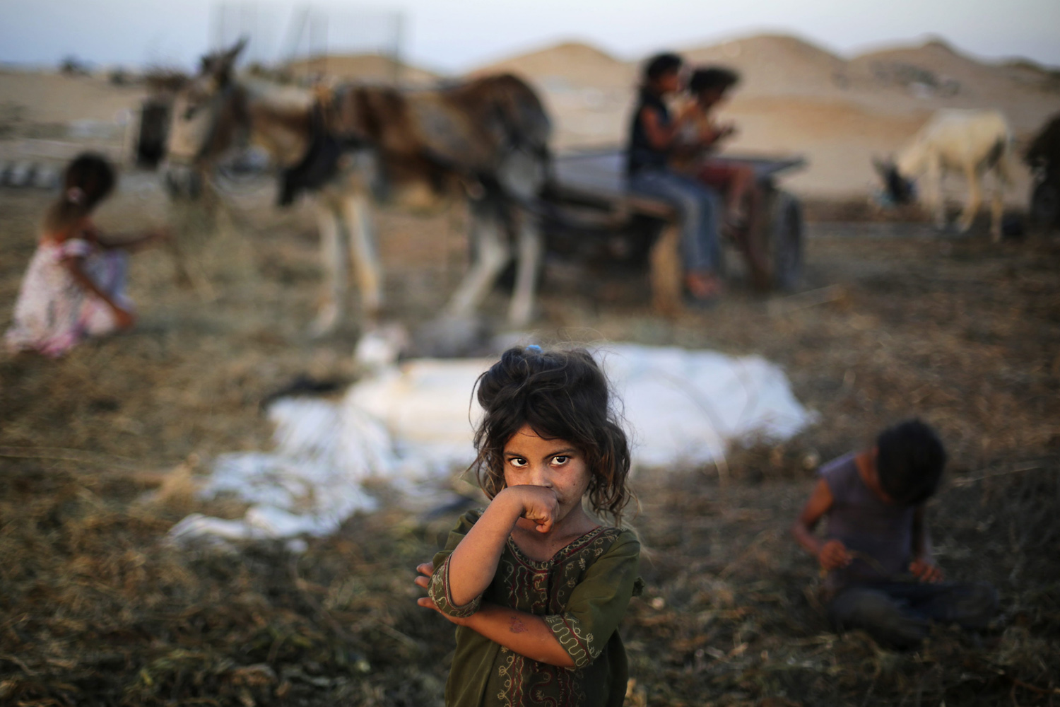 June 26, 2013. Palestinian children play outside their family's tent in a poverty-stricken quarter of the town of Younis, in the southern Gaza Strip.