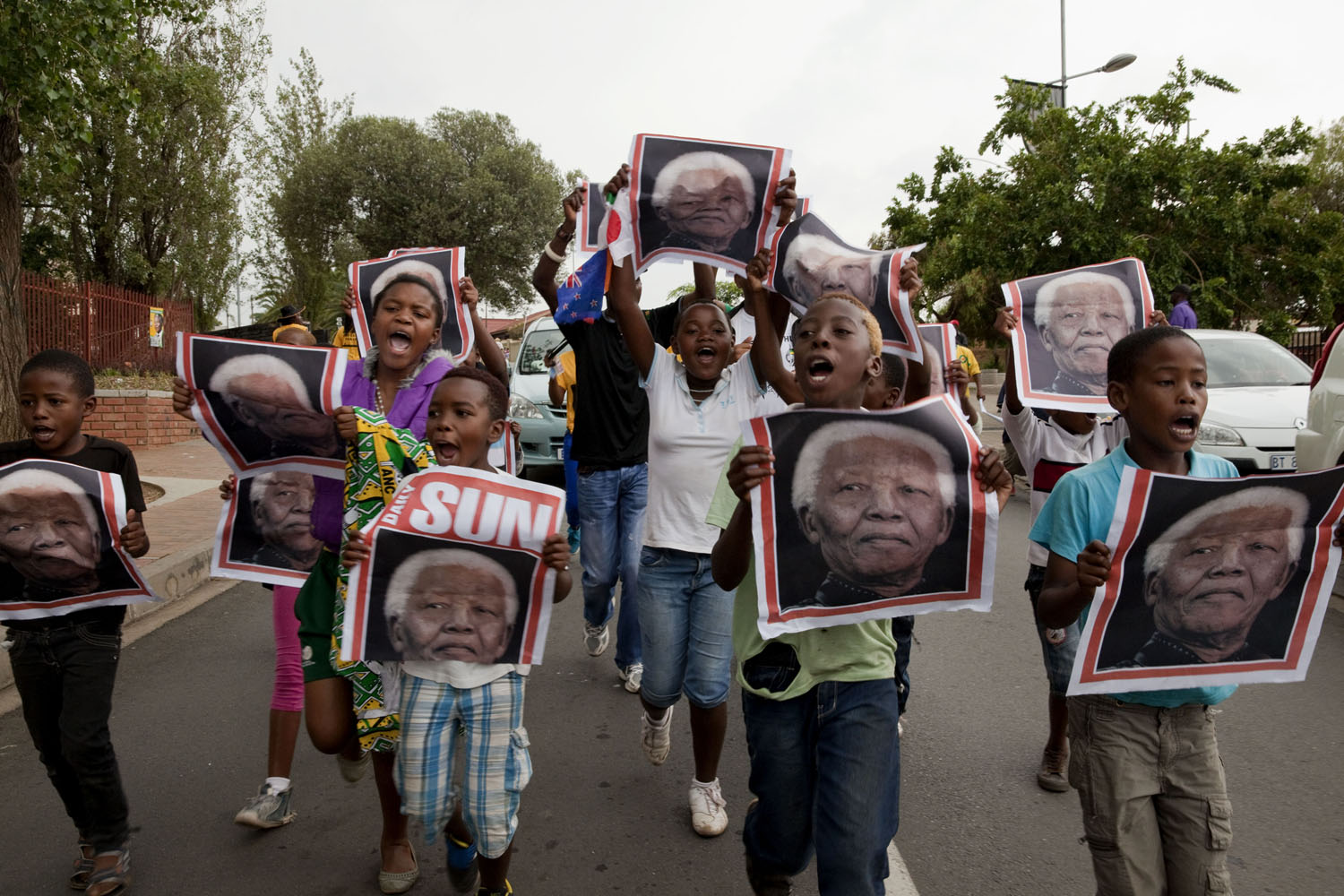 SOUTH AFRICA. Soweto. December 6, 2013. Reaction to the death of Nelson Mandela on the streets outside of his former home.