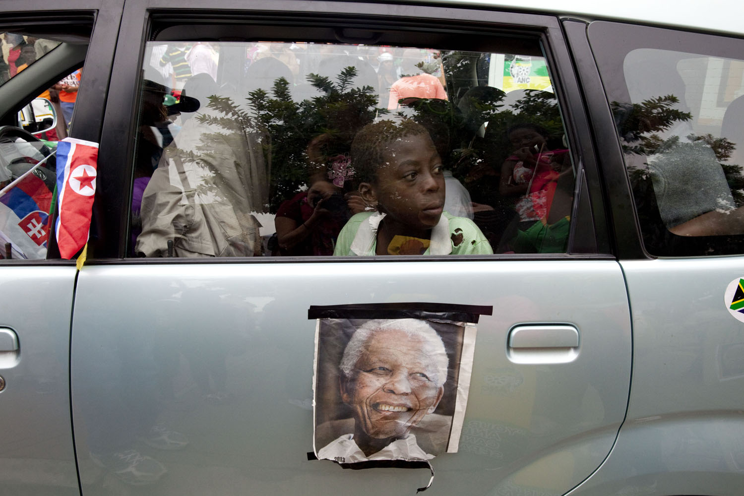 SOUTH AFRICA. Soweto. December 6, 2013. Reaction to the death of Nelson Mandela on the streets outside of his former home.