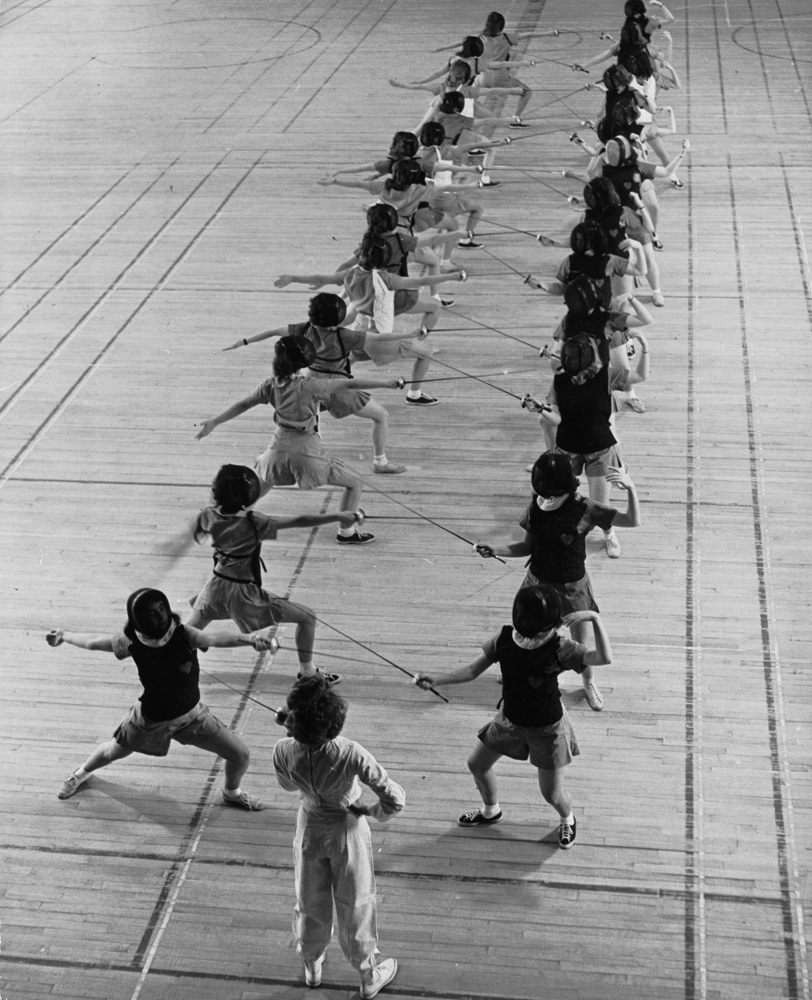 Coeds at the University of New Hampshire fencing in gymnasium, 1942.