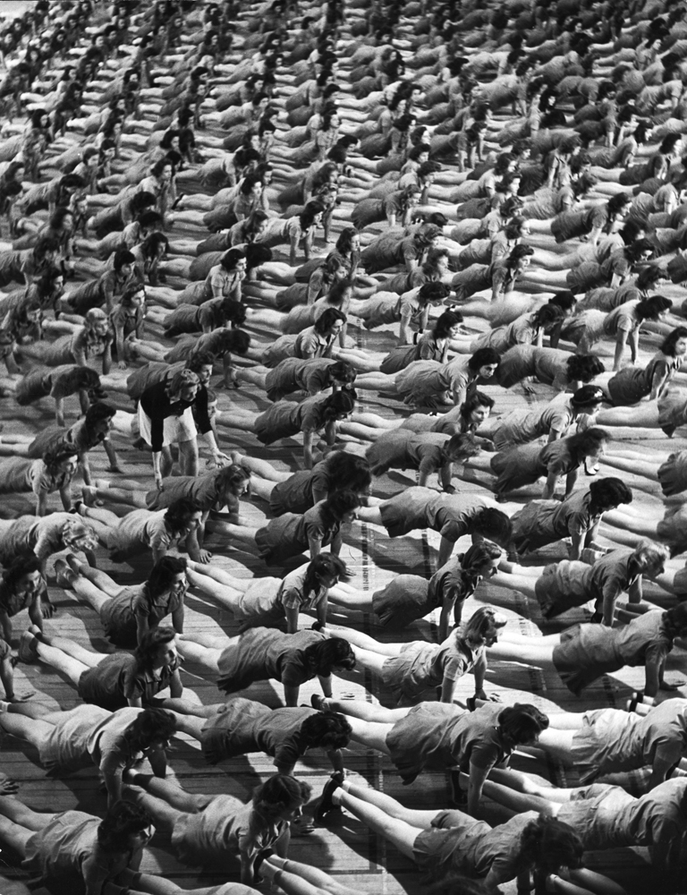 Coeds at the University of New Hampshire executing front-fall exercise on gymnasium floor, 1942.