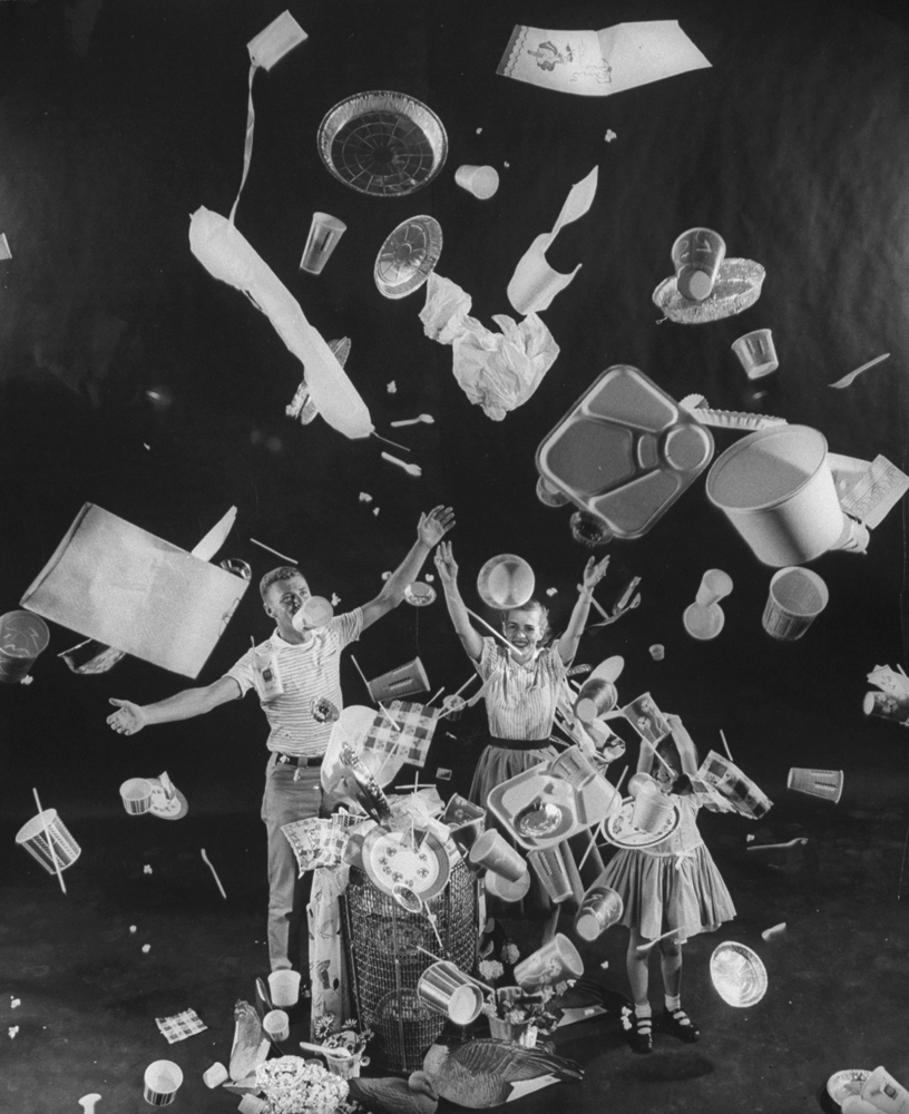 A man, woman and child toss "disposable" items into the air, 1955.