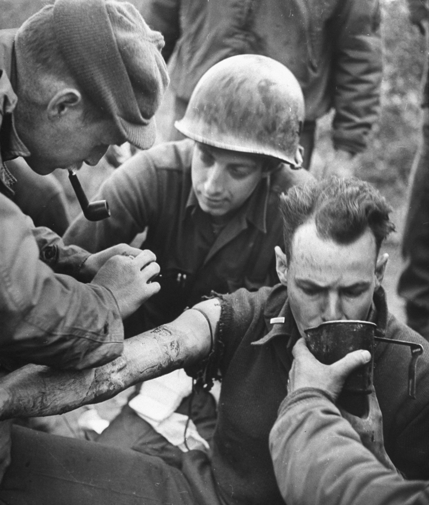 Wounded American soldier treated at battalion headquarters while awaiting an ambulance during the fighting to take Anzio, 1944.