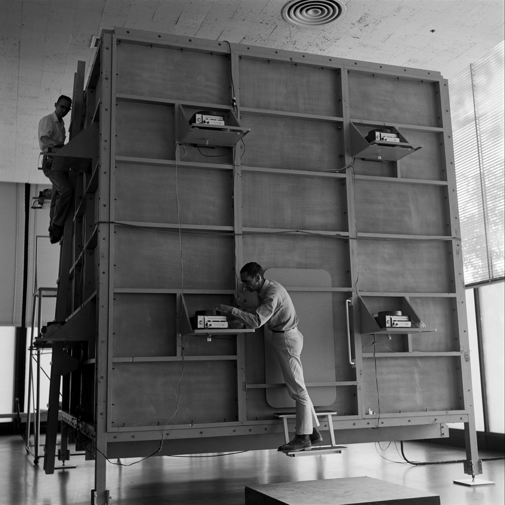 Ken Isaacs (front) and a colleague work on the outside of Isaacs' "knowledge box," Chicago, 1962.