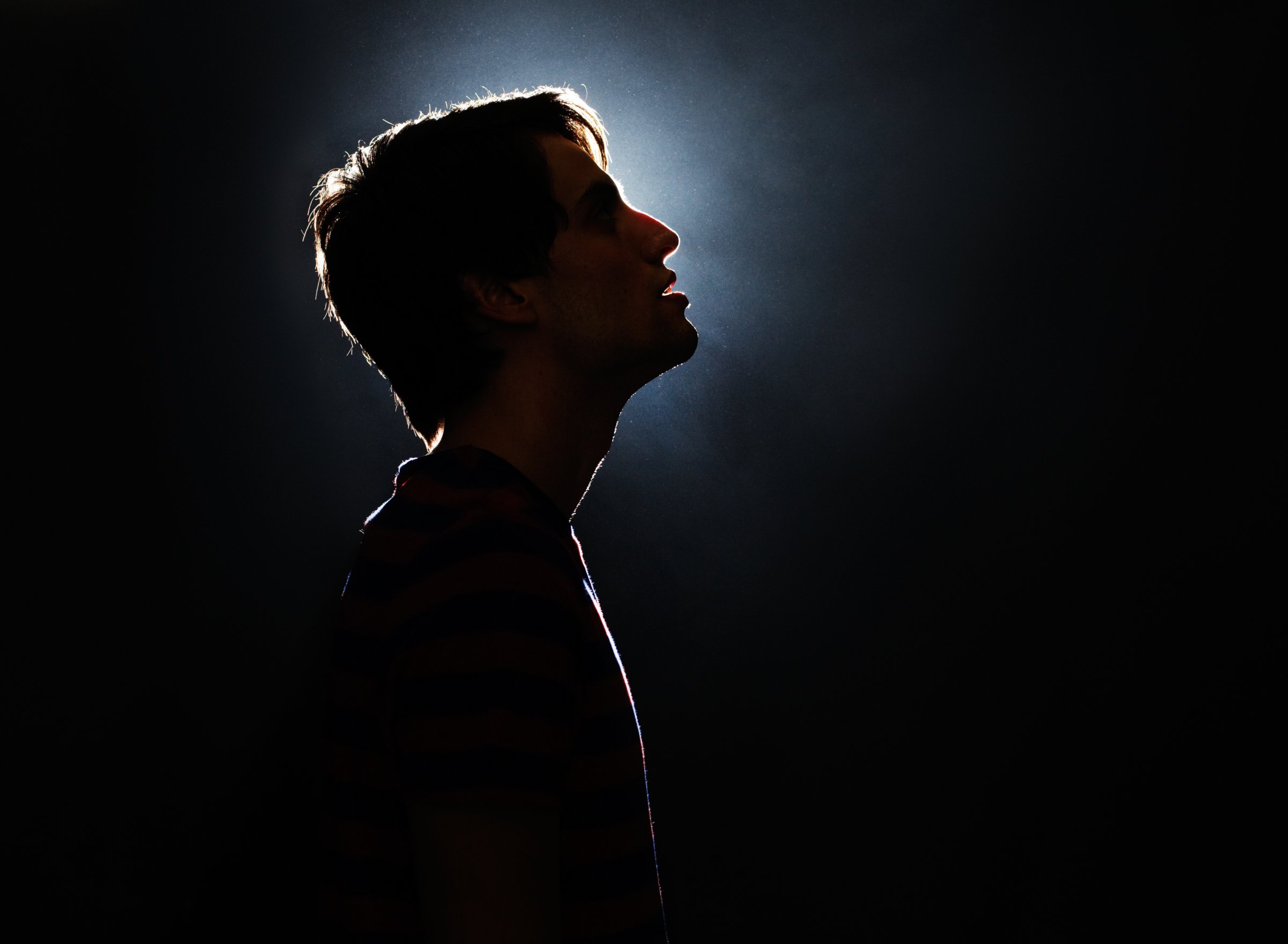 Silhouette of young man looking up.
