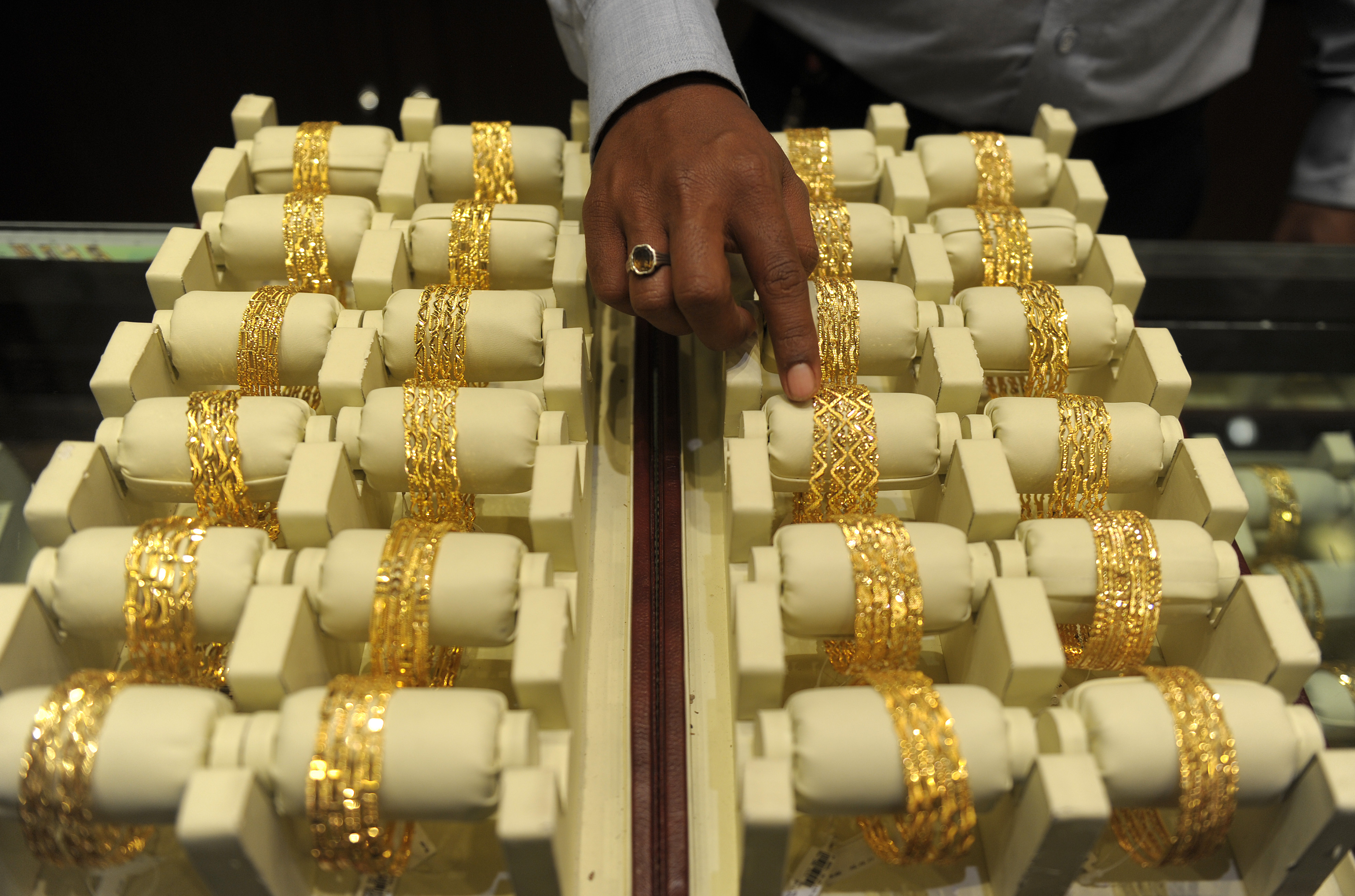 An Indian sales assistant arranges gold bangles in a jewelry shop in Hyderabad, India, on May 13, 2013 (Noah Seelam / AFP / Getty Images)