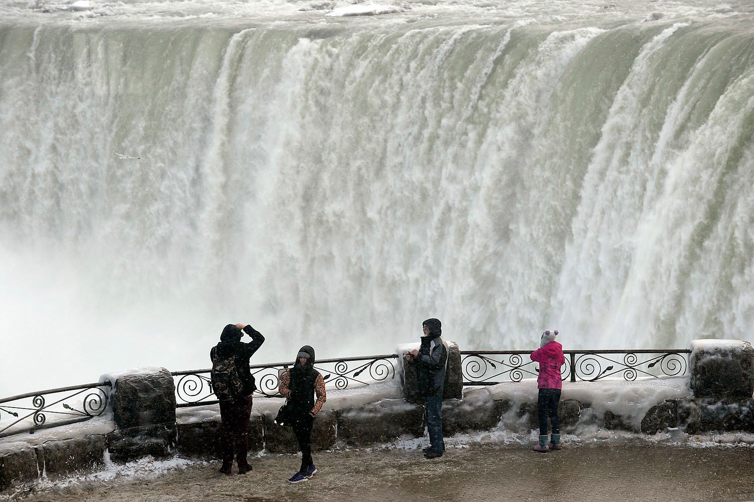 Visitors take pictures overlooking the falls in Niagara Falls, Ontario, Jan. 8, 2014.