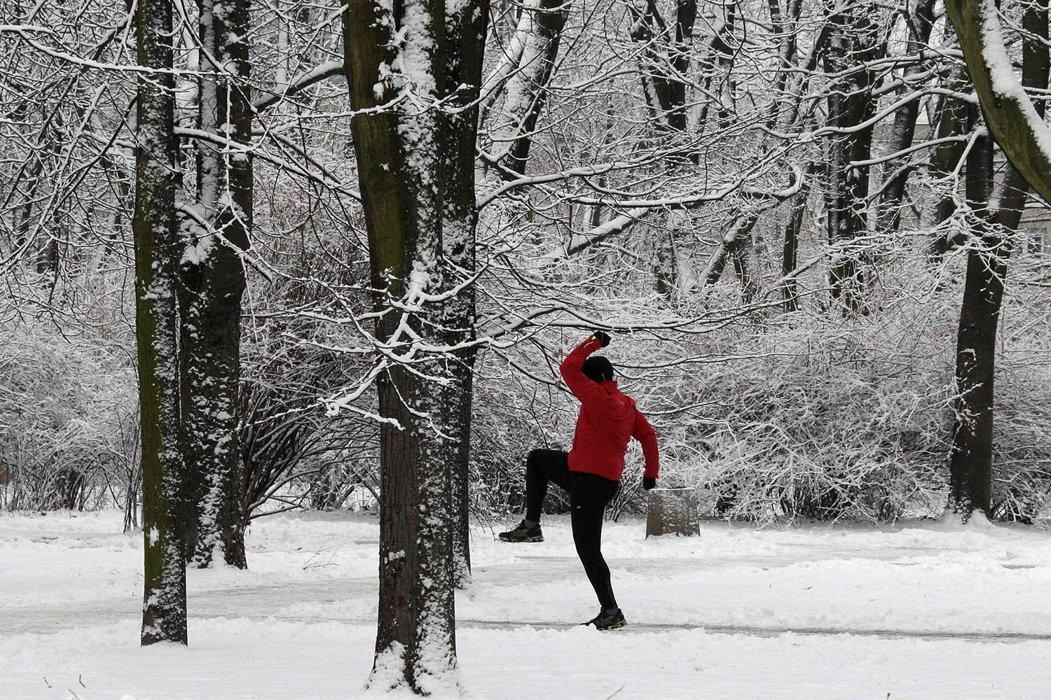 A man works out at a park covered by the first snow of the year in the centre of Warsaw