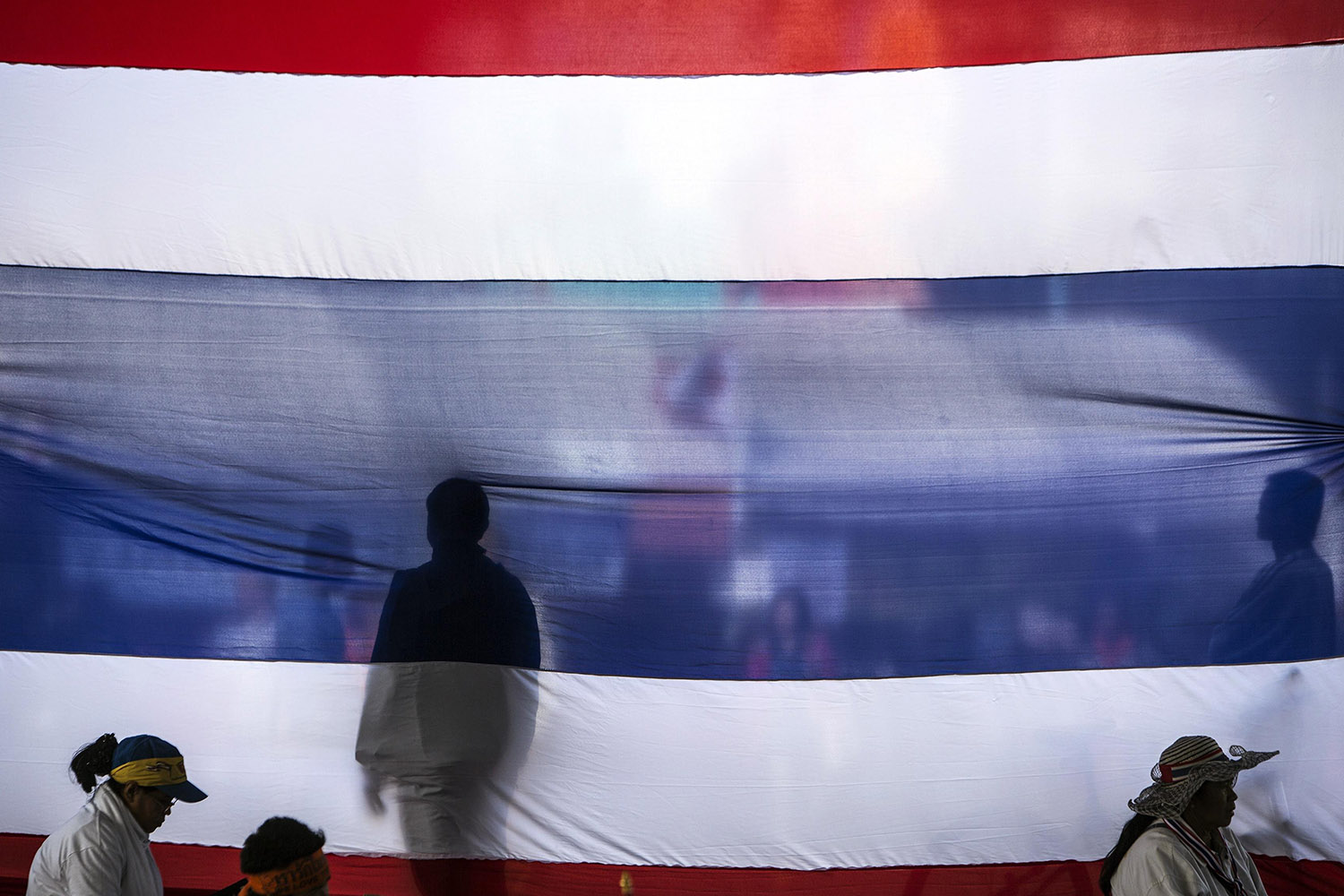 Jan. 19, 2014. Anti-government protesters stand next to a Thai national flag at the Victory monument in Bangkok, Thailand.