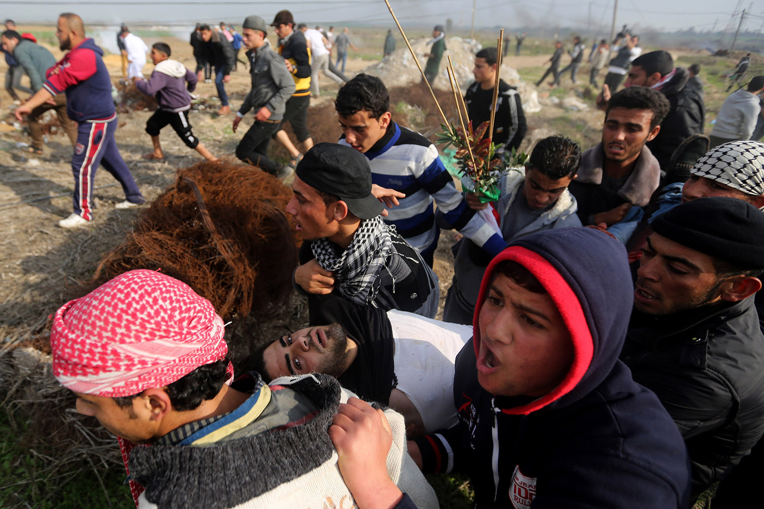 Jan. 17, 2014. Palestinians carry a wounded protester during clashes with Israeli security forces following a protest in Nahal Oz, east of Gaza City.