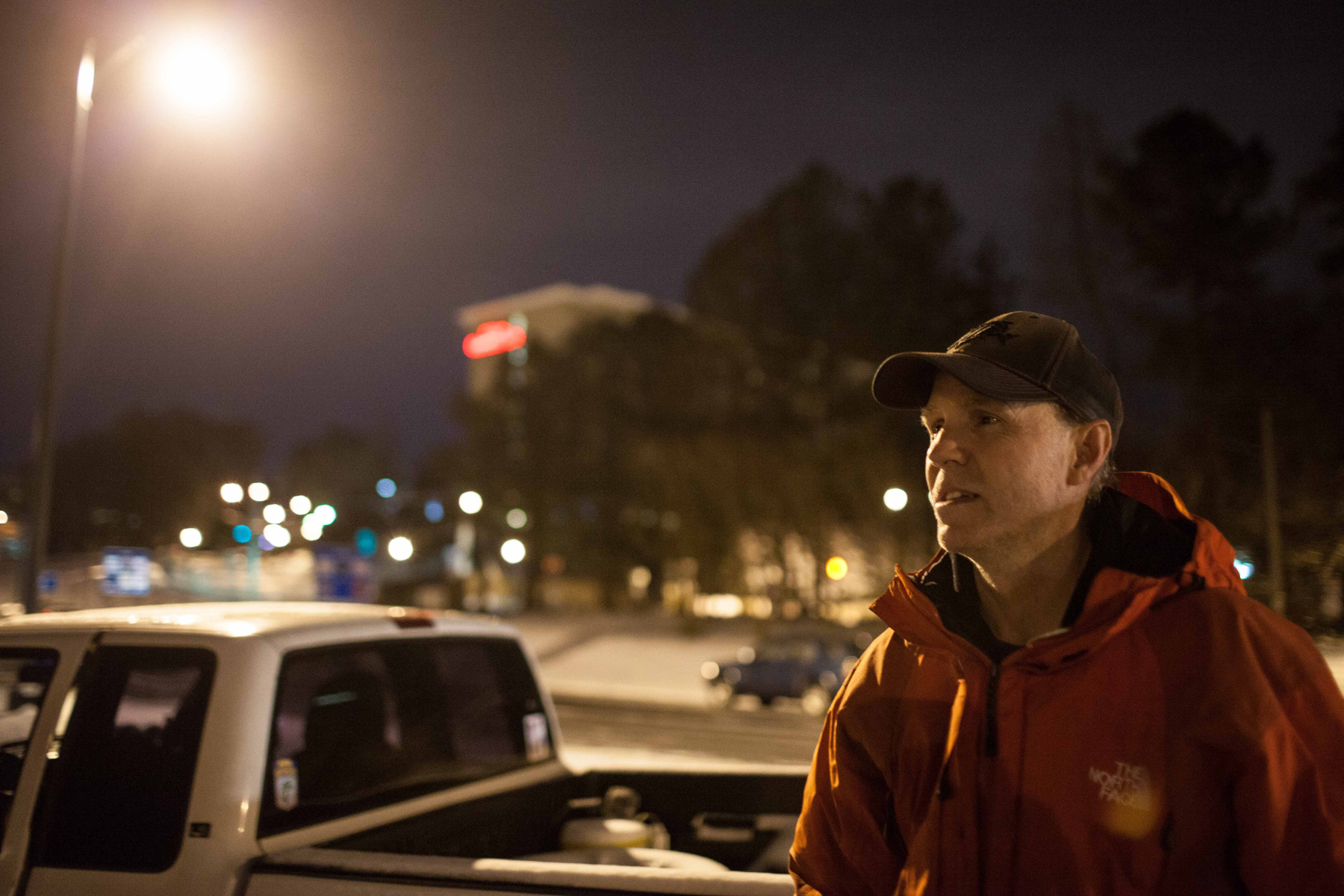 Jeff Brown stands outside of his truck that he slept in Tuesday night after being stranded on Interstate 285, early Wednesday, Jan. 29, 2014, in Dunwoody, Ga.