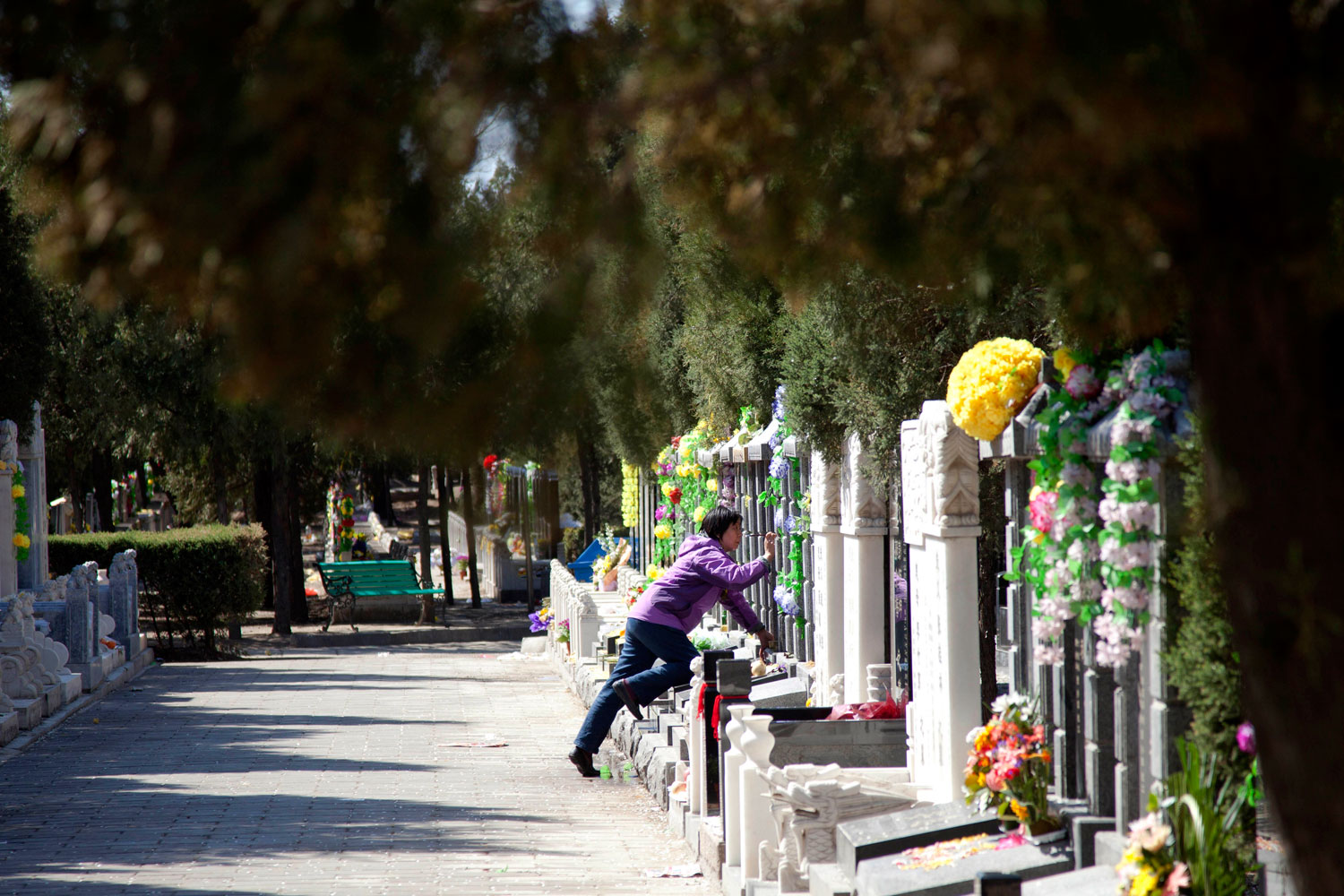 A lady cleans a gravestone two days before Tomb-Sweeping Day at Babaoshan Cemetery on April 3, 2011 in Beijing, China (ChinaFotoPress / Getty Images)