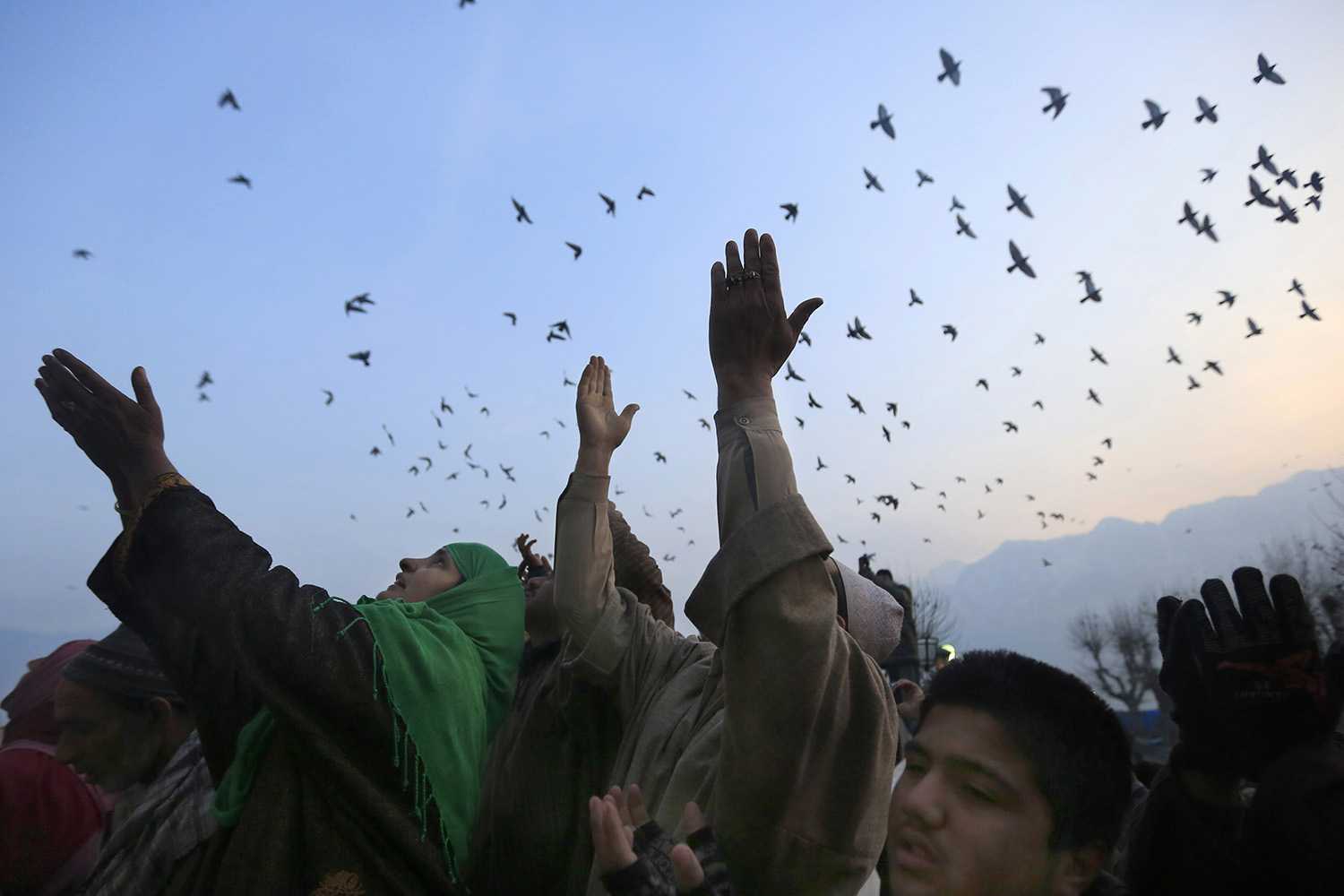 Jan. 17, 2014. Kashmiri Muslim devotees raise their hands as a head priest displays a relic of Islam's Prophet Muhammad at the Hazratbal shrine on the Friday following Eid-e-Milad, the birth anniversary of the Prophet, in Srinagar, India.