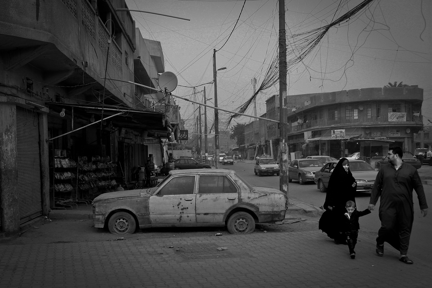 Apr. 17, 2012. Baghdad. A family passes a car full of bullet holes.