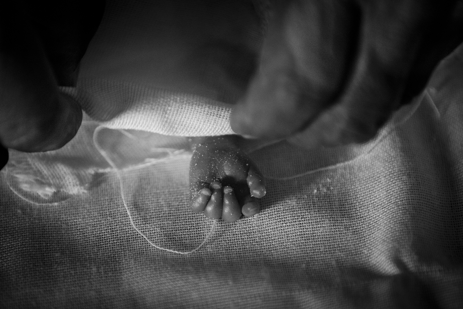 Apr. 22, 2012. Basra. The hand of a stillborn baby is wrapped in linen cloth.