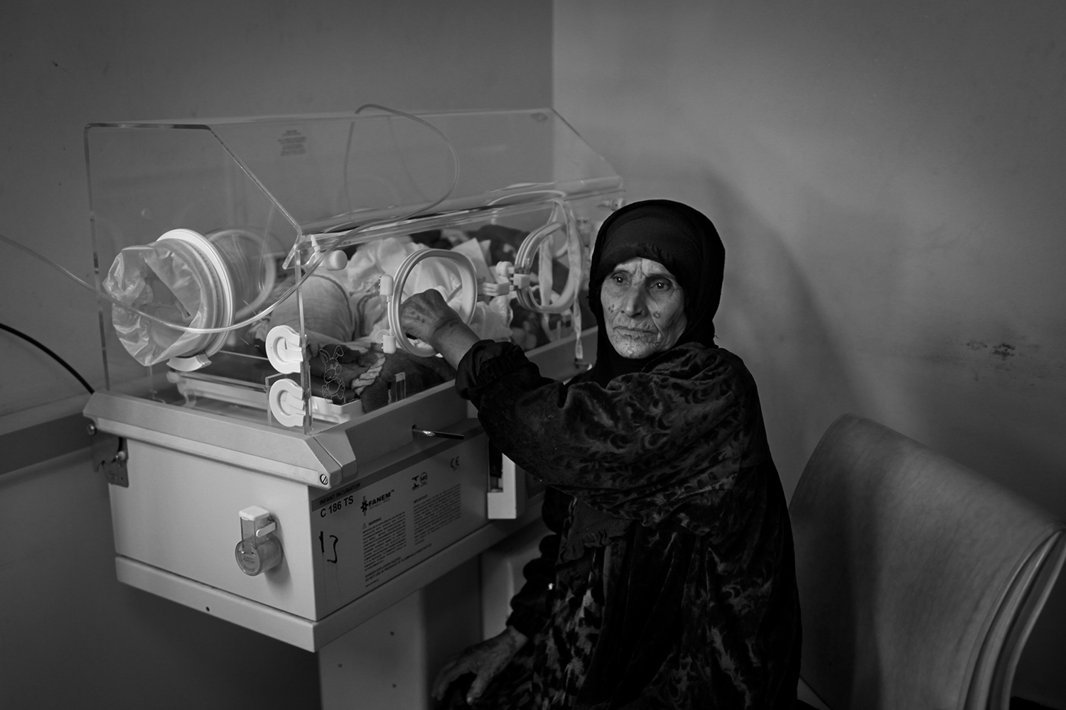 Apr. 18, 2012. Fallujah. An elderly woman holds her granddaughter's hand inside an incubator in the neonatal ward of the General Hospital. The child was born with leukemia and cerebral tumors.