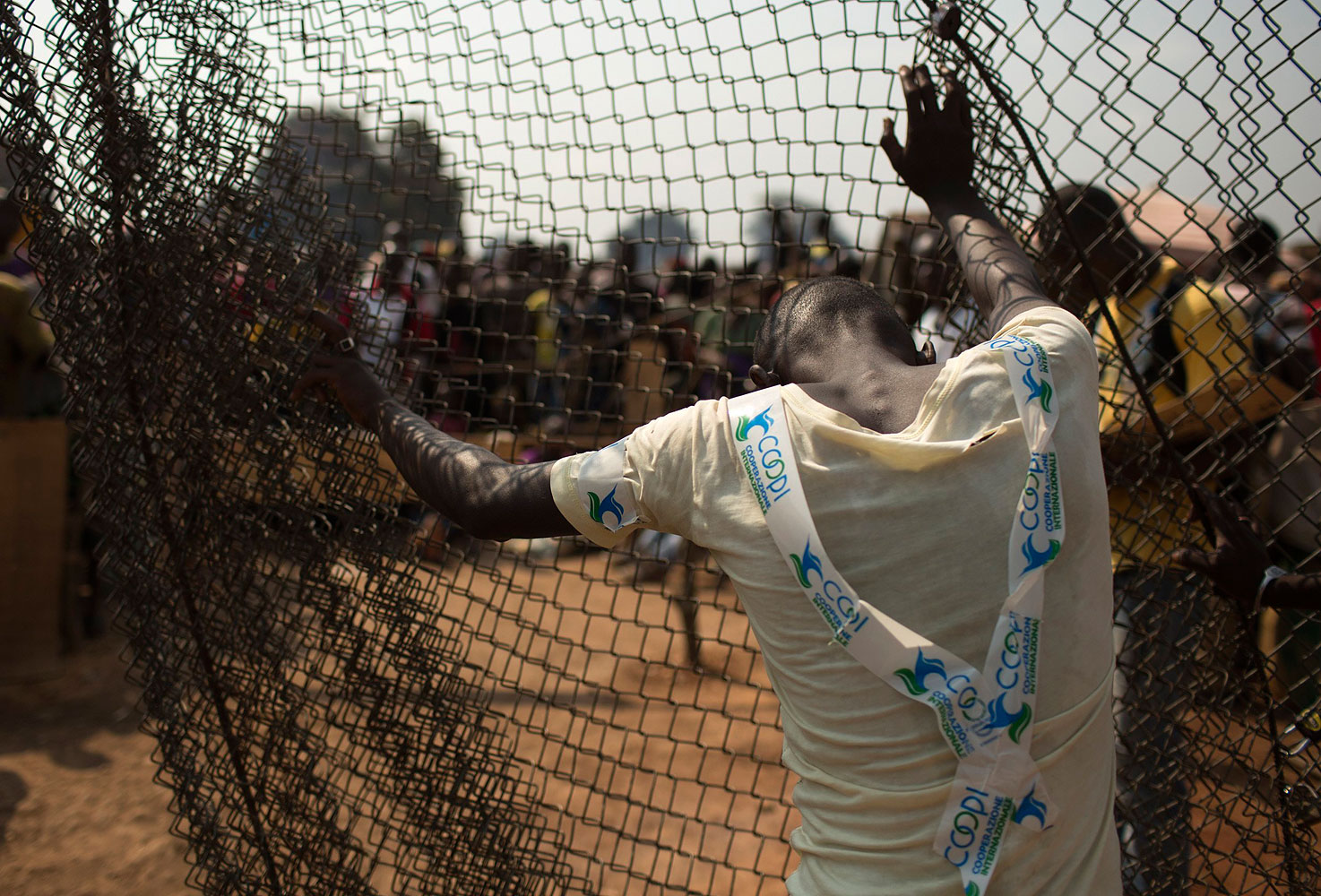 A man stands by a fence at the edge of a camp for internally displaced persons at the airport of the capital Bangui, Jan. 21, 2014.