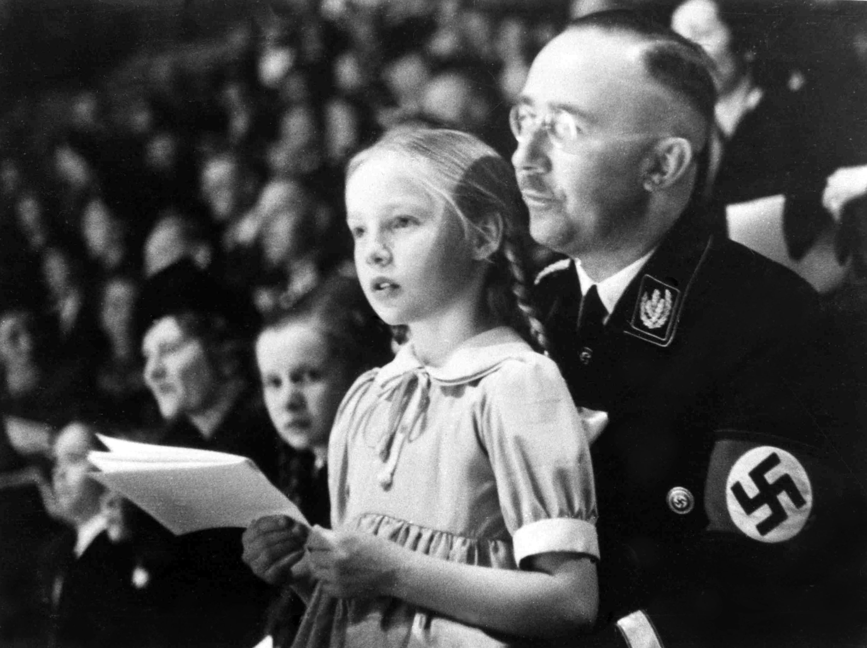 From right: Chief of the German Police and Minister of the Interior Heinrich Himmler with his daughter Gudrun on his lap watch an indoor sports display in Berlin, on March 6, 1938. (AP)