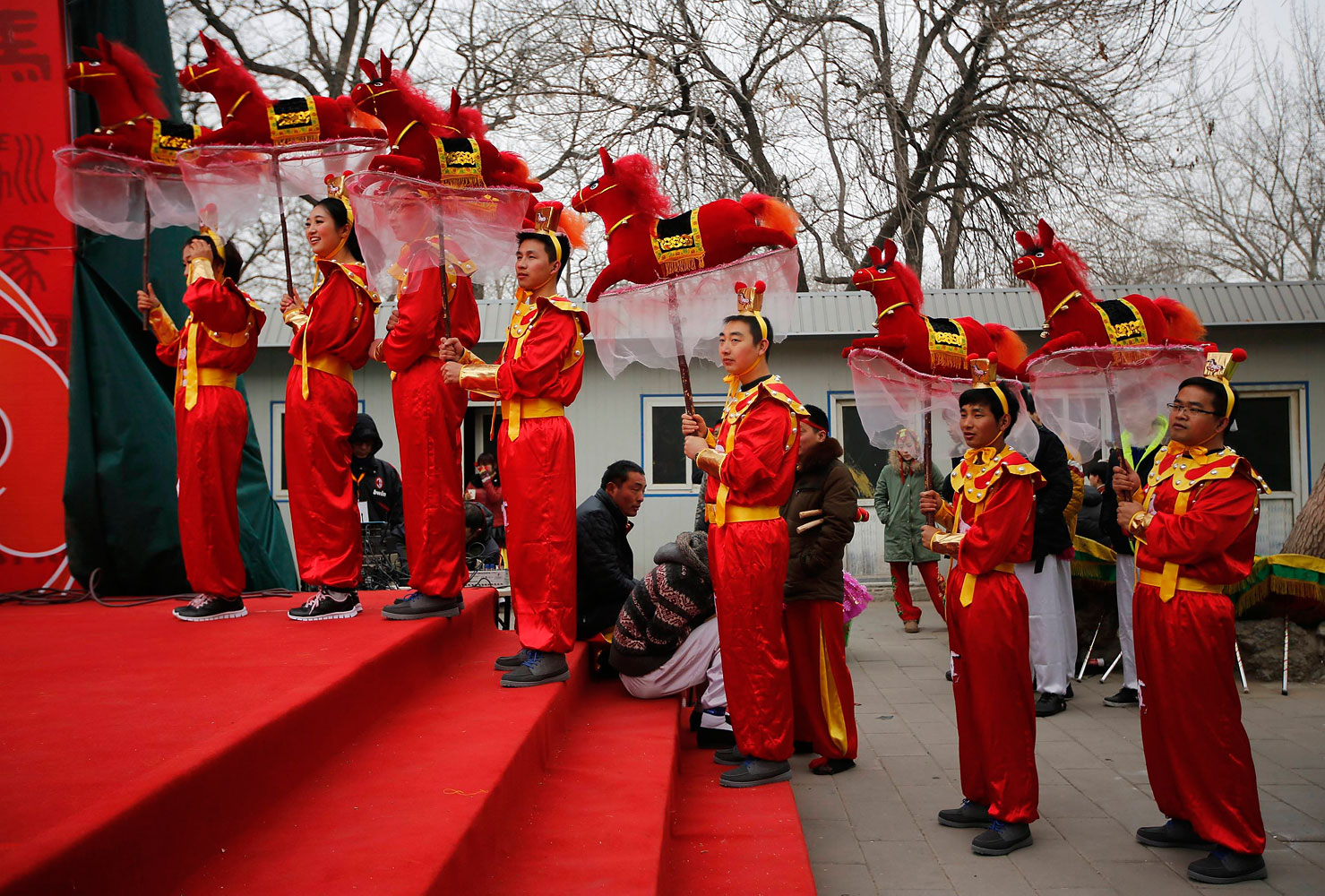 Folk dancers hold horse models as they prepare to take part in a traditional horse dance on the first day of the Chinese Lunar New Year, which welcomes the Year of the Horse, at the Longtan park in Beijing Jan. 31, 2014.