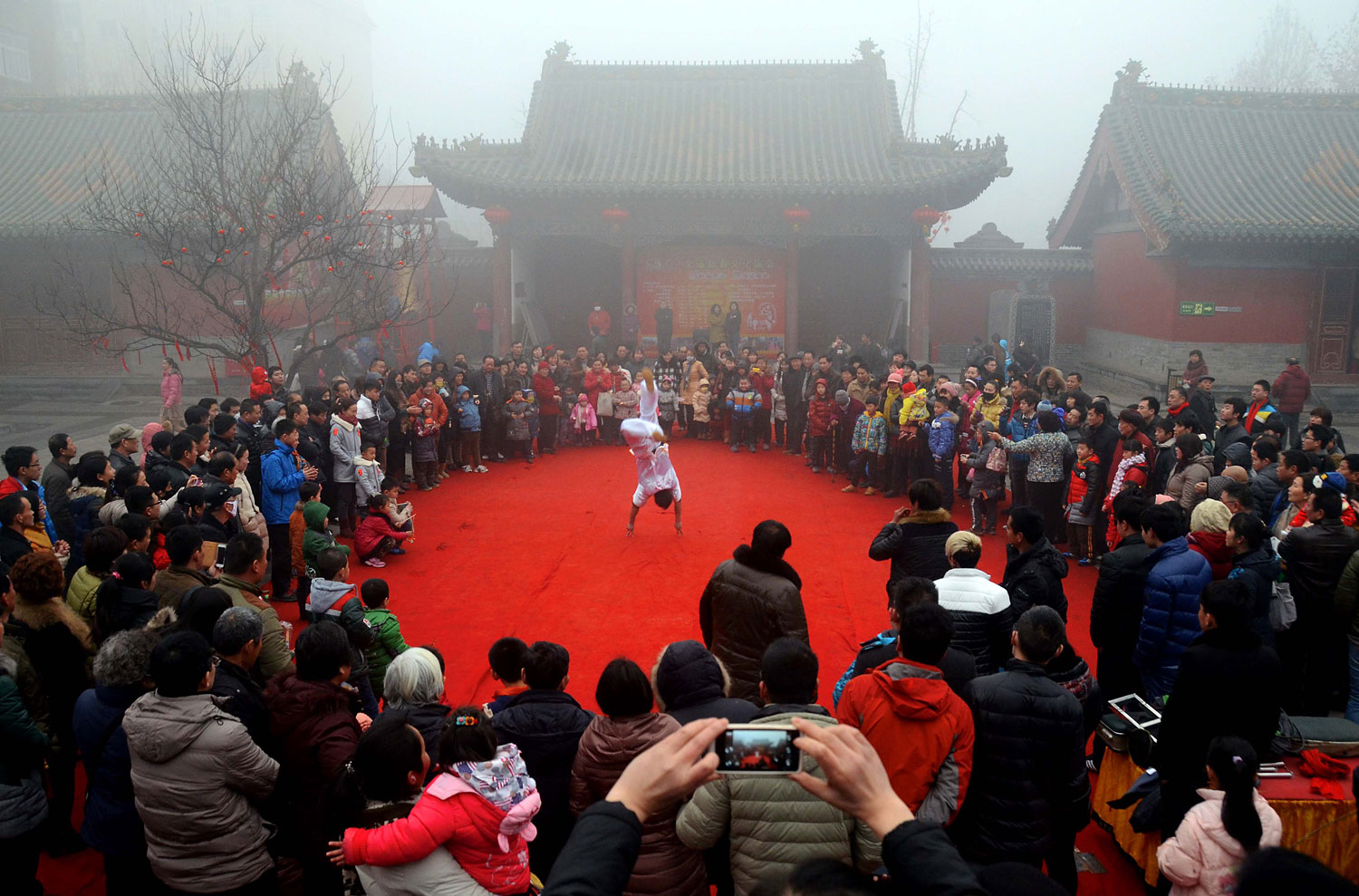 Visitors view a performance at a temple fair celebrating the Lunar New Year, known as the Spring Festival, in Zhengzhou, capital of Central China's Henan Province, Jan. 31, 2014.