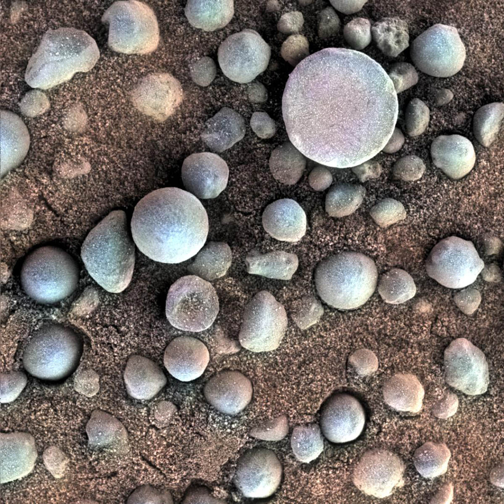 Tiny spherules, photographed by Opportunity, pepper a sandy surface in this 1.2-in (3 cm) square view of the Martian soil. Nicknamed  blueberries  by mission scientists, the little pellets are actually hematites, an iron oxide typically formed in standing water—of which Mars once had plenty.