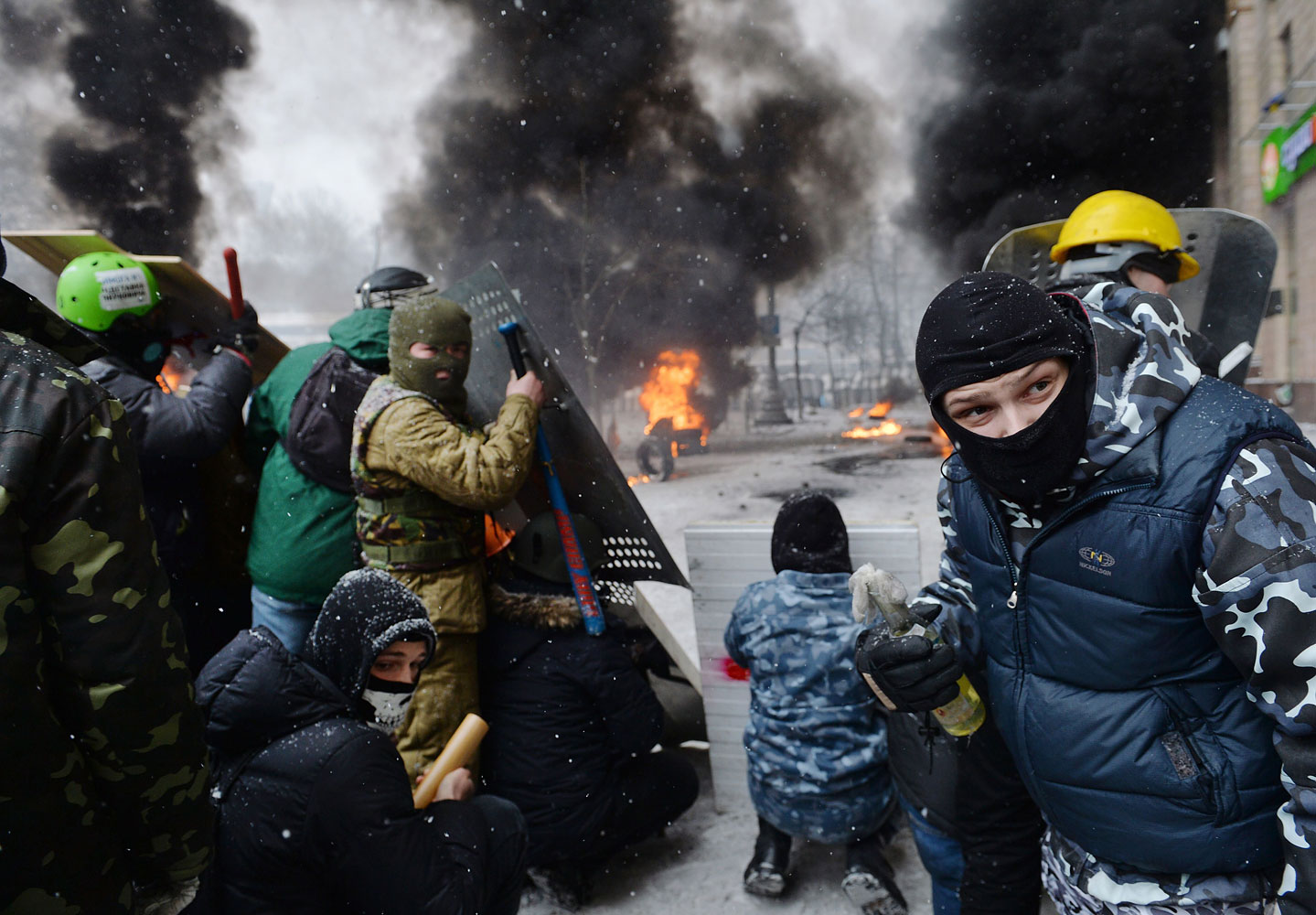 A demonstrator holds an incendiary device as protesters clash with police in the center of Kiev,  Jan. 22, 2014.