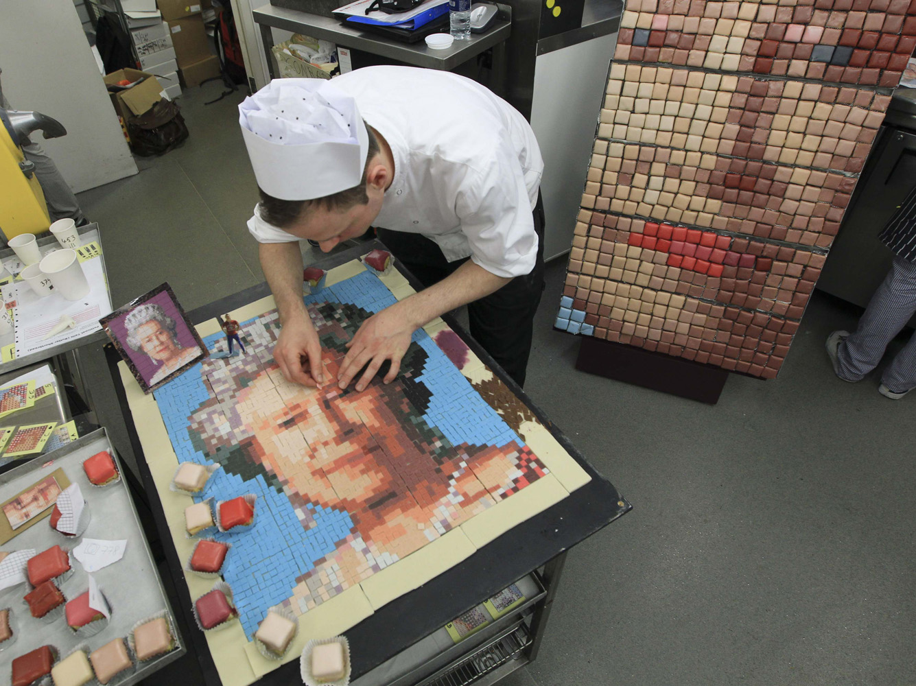 A baker poses with a marzipan mosaic of Britain's Queen Elizabeth in the City of London