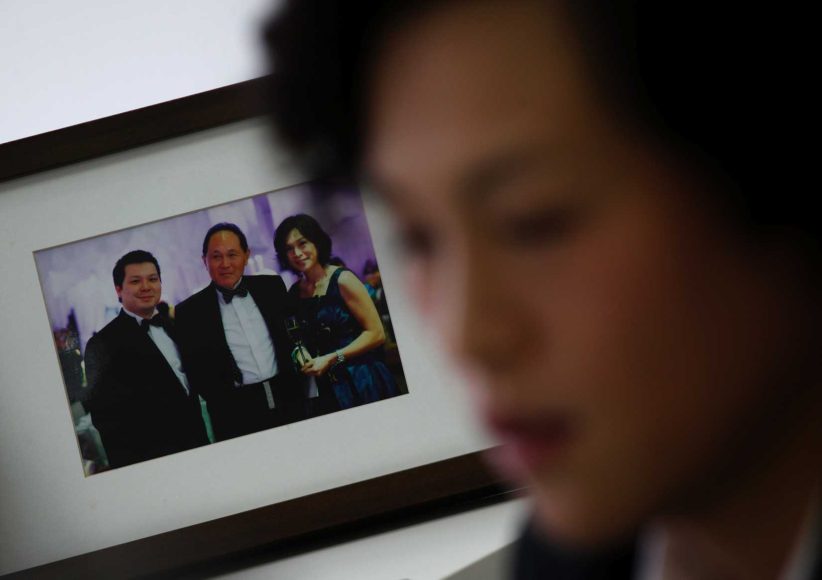 Gigi Chao, the daughter of Hong Kong property tycoon Cecil Chao, next to a family photo of herself; her father, center; and brother Howard at her office in Hong Kong on Sept. 27, 2012 (Bobby Yip / Reuters)