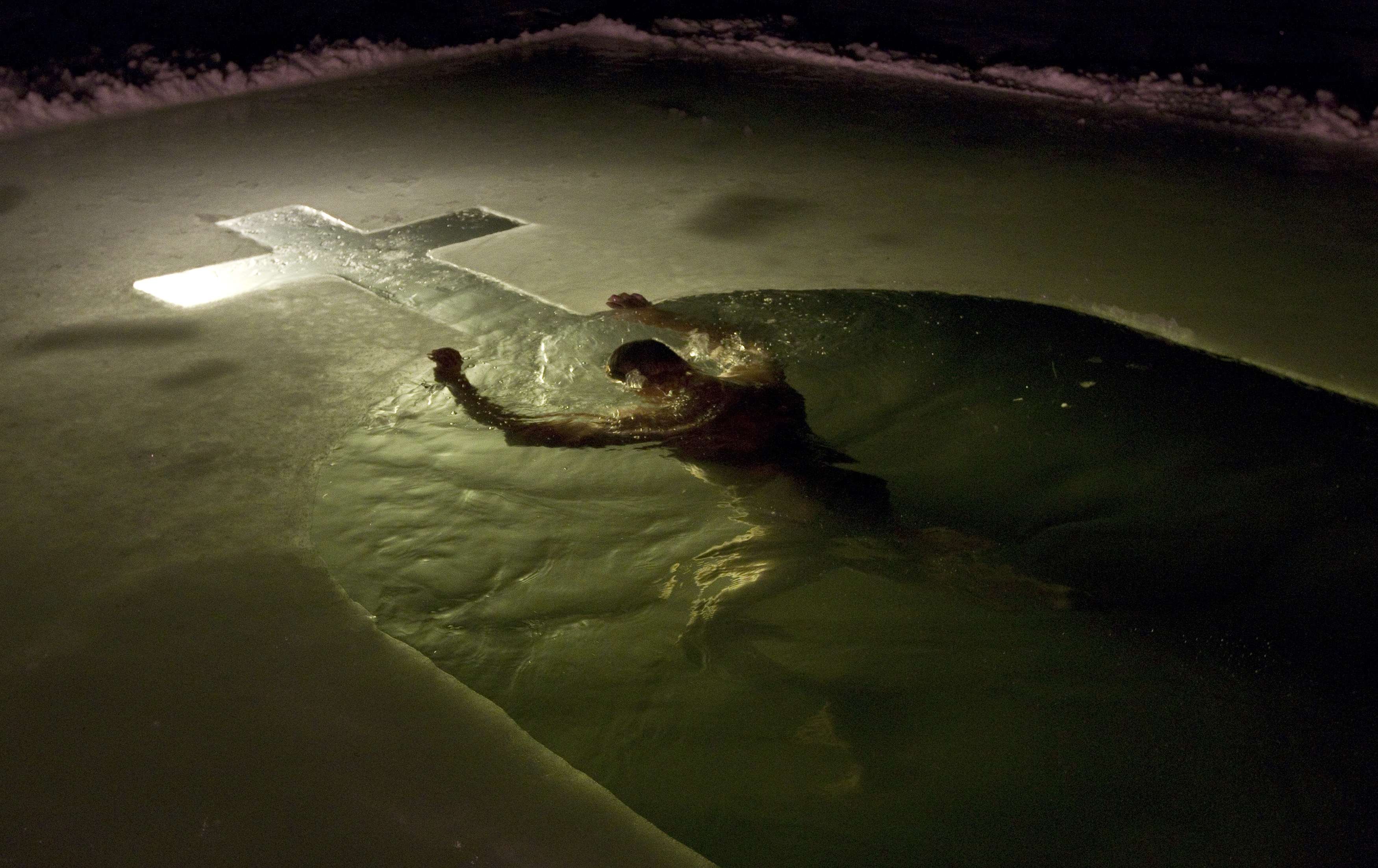 A man swims in a lake in Minsk, Jan. 18, 2014. Orthodox believers mark Epiphany by immersing themselves in icy waters regardless of the weather.