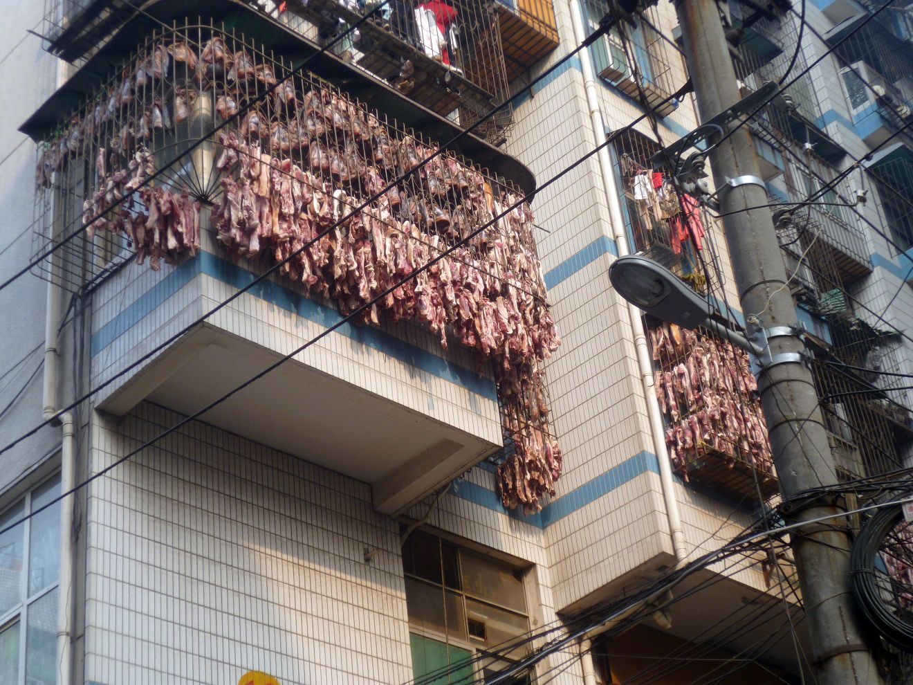 Bacon hangs to dry from a third-floor apartment window in Wuhan, China, Jan. 9, 2014.