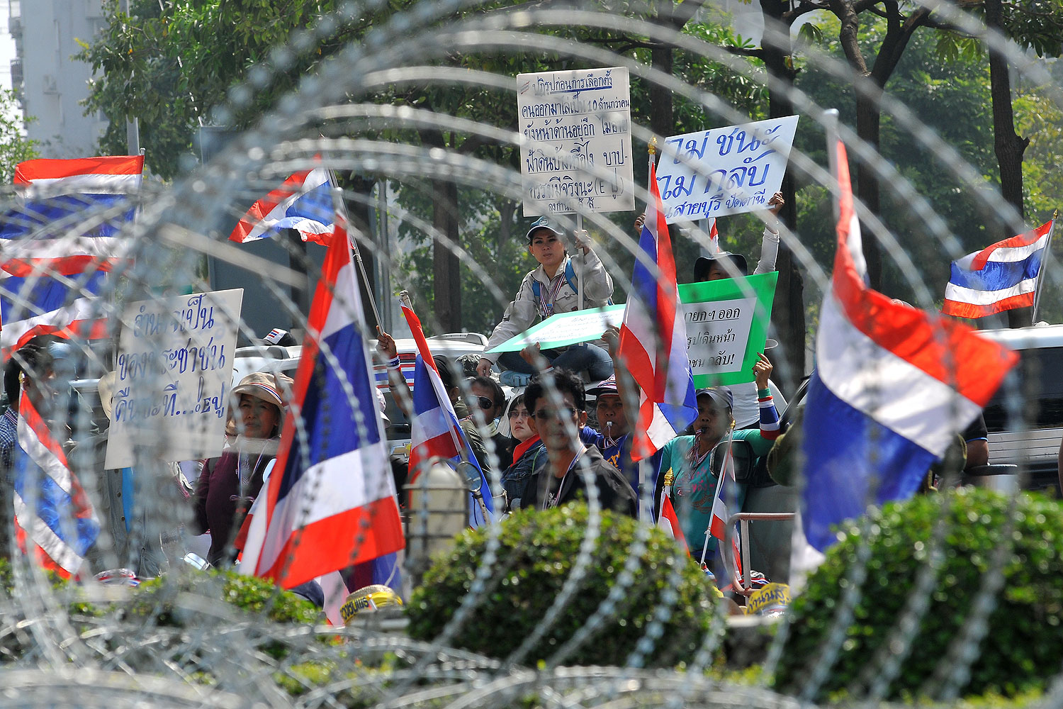 Anti-government protesters wave national flags as they block the street in front of the Office of the Defence Permanent Secretary during a rally in Bangkok on Jan. 22, 2014 (AFP / Getty Images)