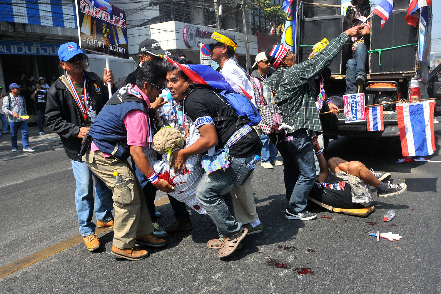Anti-government protesters help a fellow protester injured in a grenade attack during a rally in Bangkok Jan. 17, 2014 (Reuters)