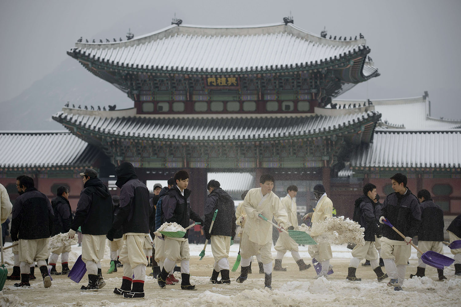 Jan. 20, 2014.
                              Workers clear snow inside the Gyeongbokgung Palace following overnight snowfall in Seoul, South Korea.
