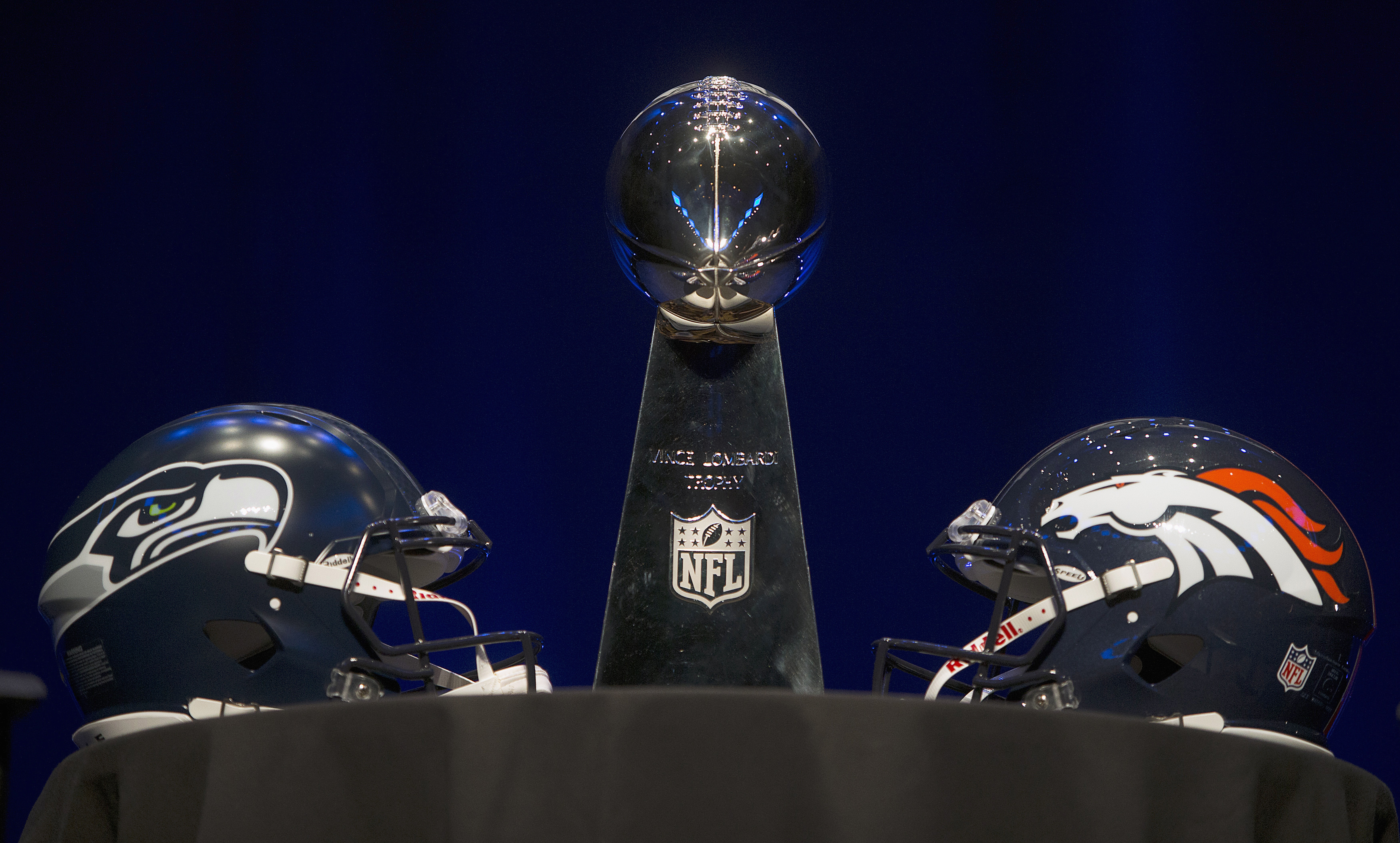 The Vince Lombardi trophy and Seattle Seahawks and Denver Broncos helmets at a press conference in advance of the Super Bowl in New York City, Jan. 31, 2014.