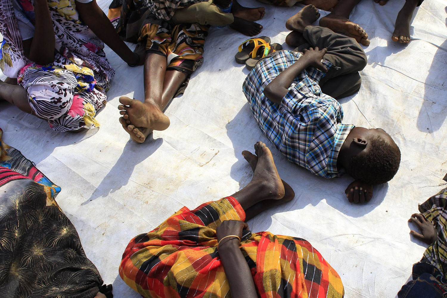 Displaced people rest as they wait for medical attention at an emergency clinic at Tomping camp in Juba