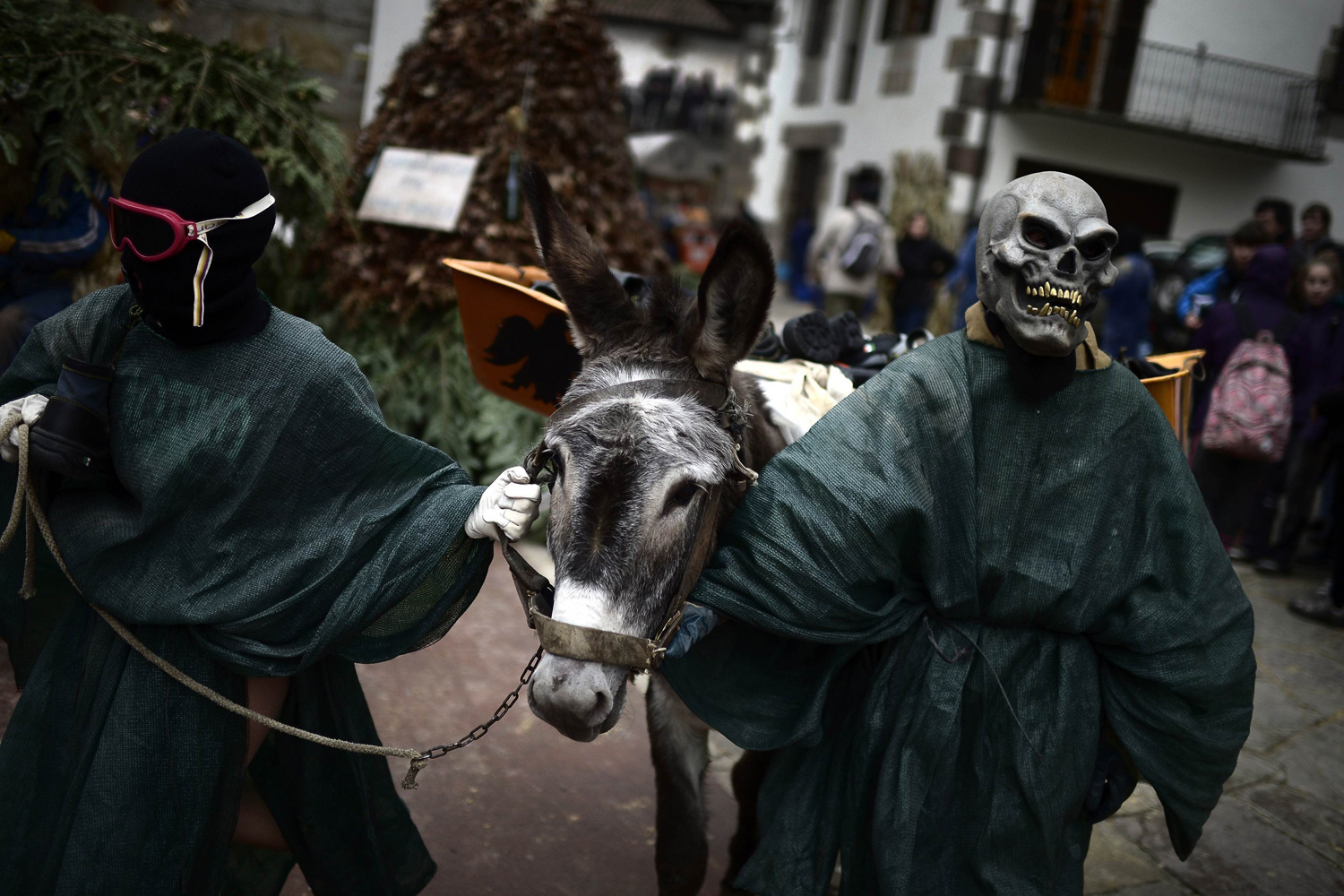 Masked men lead a donkey through the streets during carnival celebrations in Zubieta