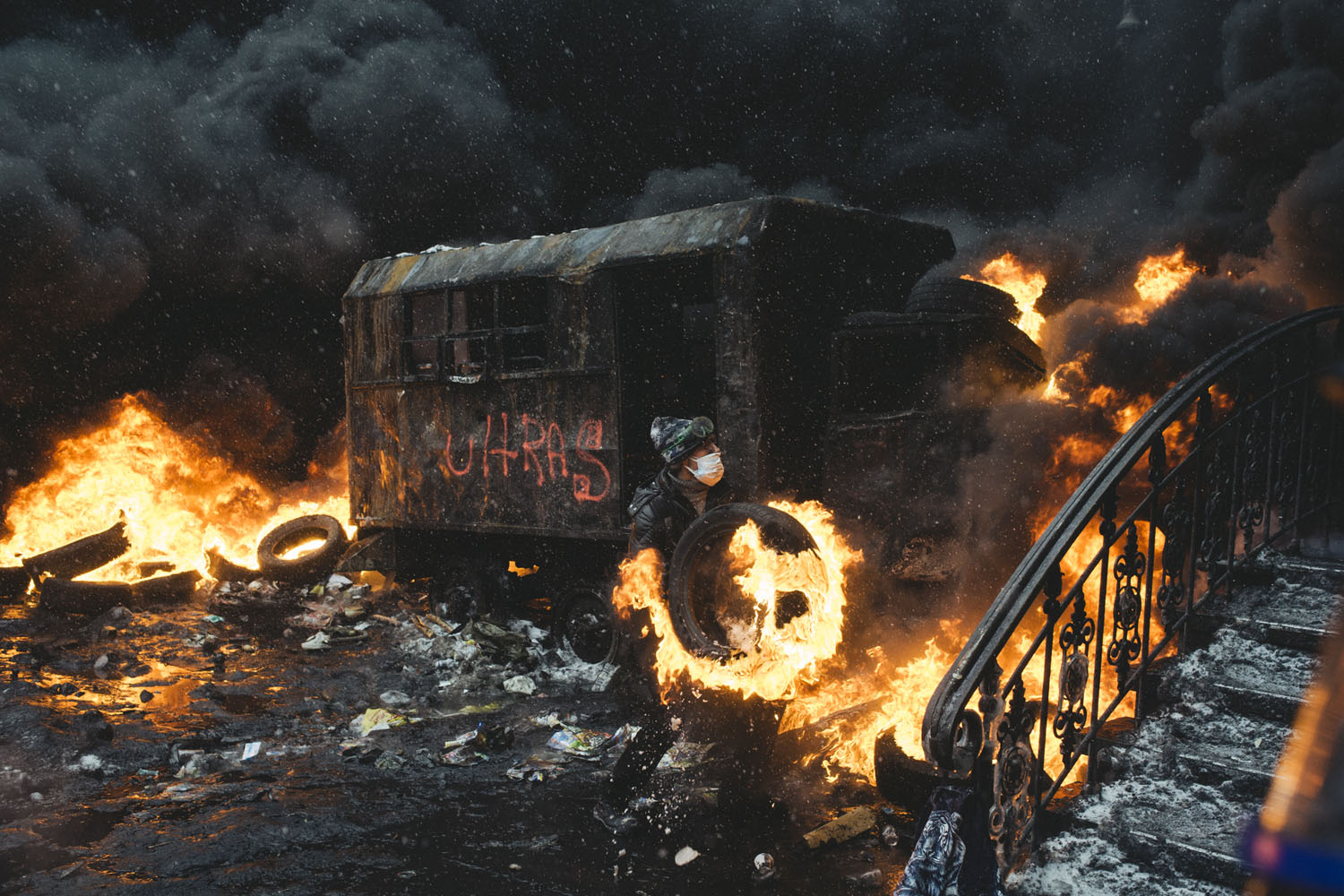 Jan. 22, 2014. A protester carries a burning car ramp closer to the riot police cordon in the center of Kiev, Ukraine.