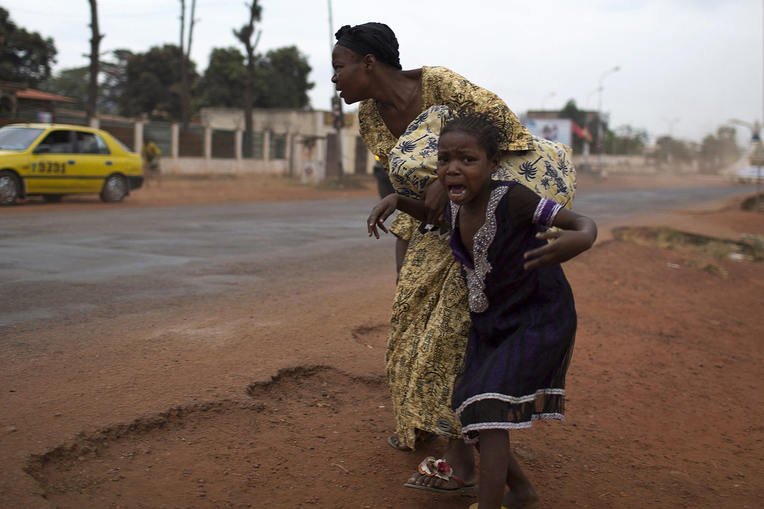 A mother holds her child while attempting to take cover as repeated gun shots are heard close to Miskine district during continuing sectarian violence in the capital Bangui