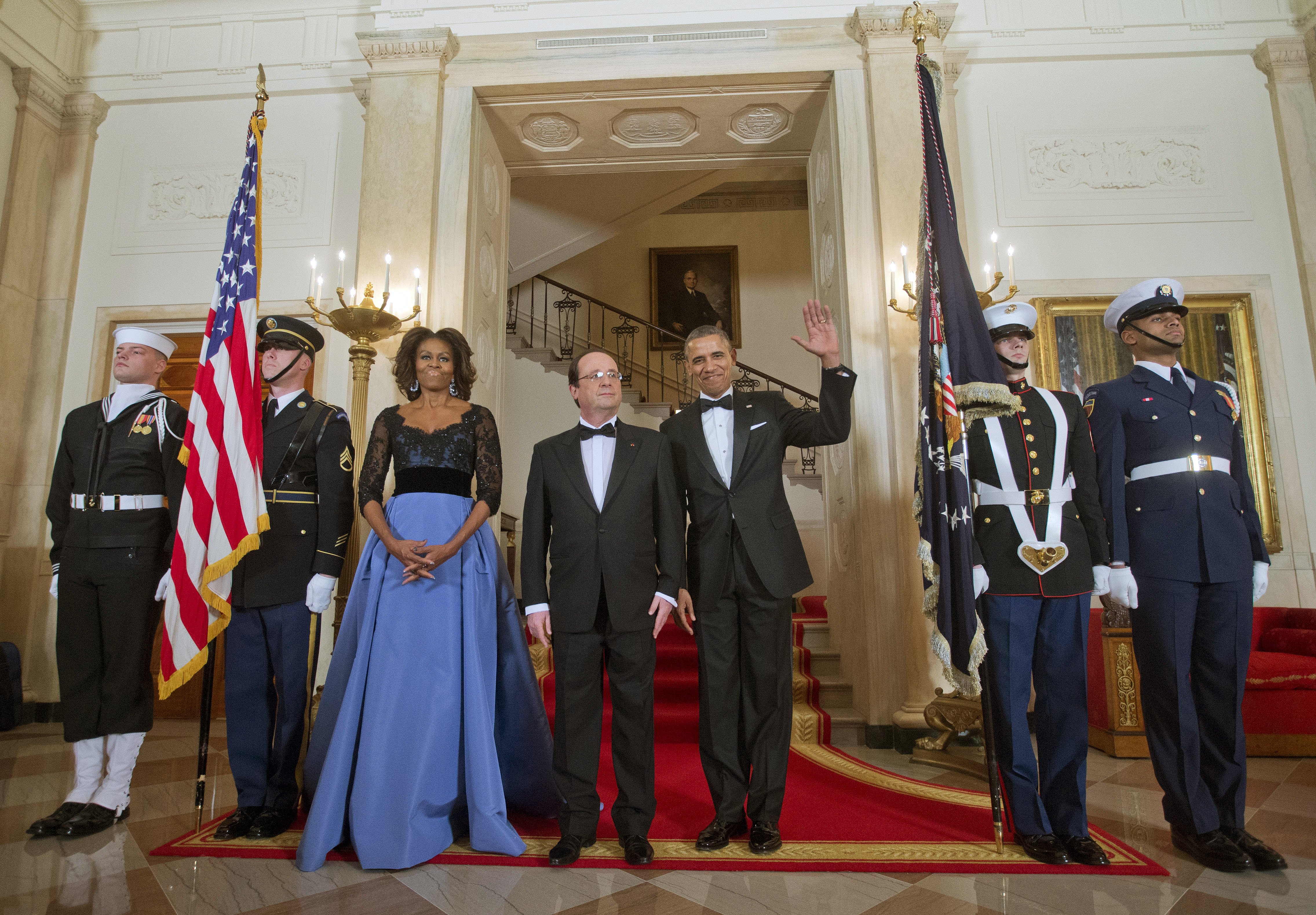 First Lady Michelle Obama and President Barack Obama with French President Francois Hollande, center, pose at the Grand Staircase as they arrive for a State Dinner, Tuesday, Feb. 11, 2014, at the White House in Washington.