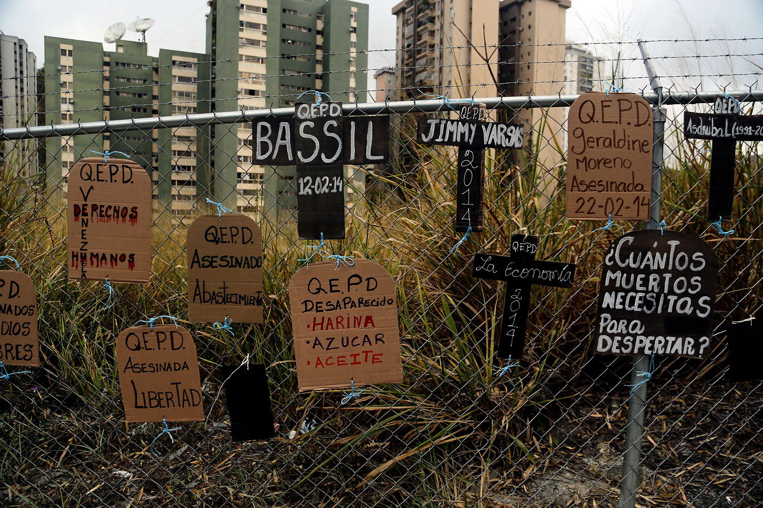 Cardboard cutouts in shapes of headstones and crosses and tied to a fence, bear anti-government protest slogans and names of those who have died in recent protests, in Caracas, March 5, 2014.