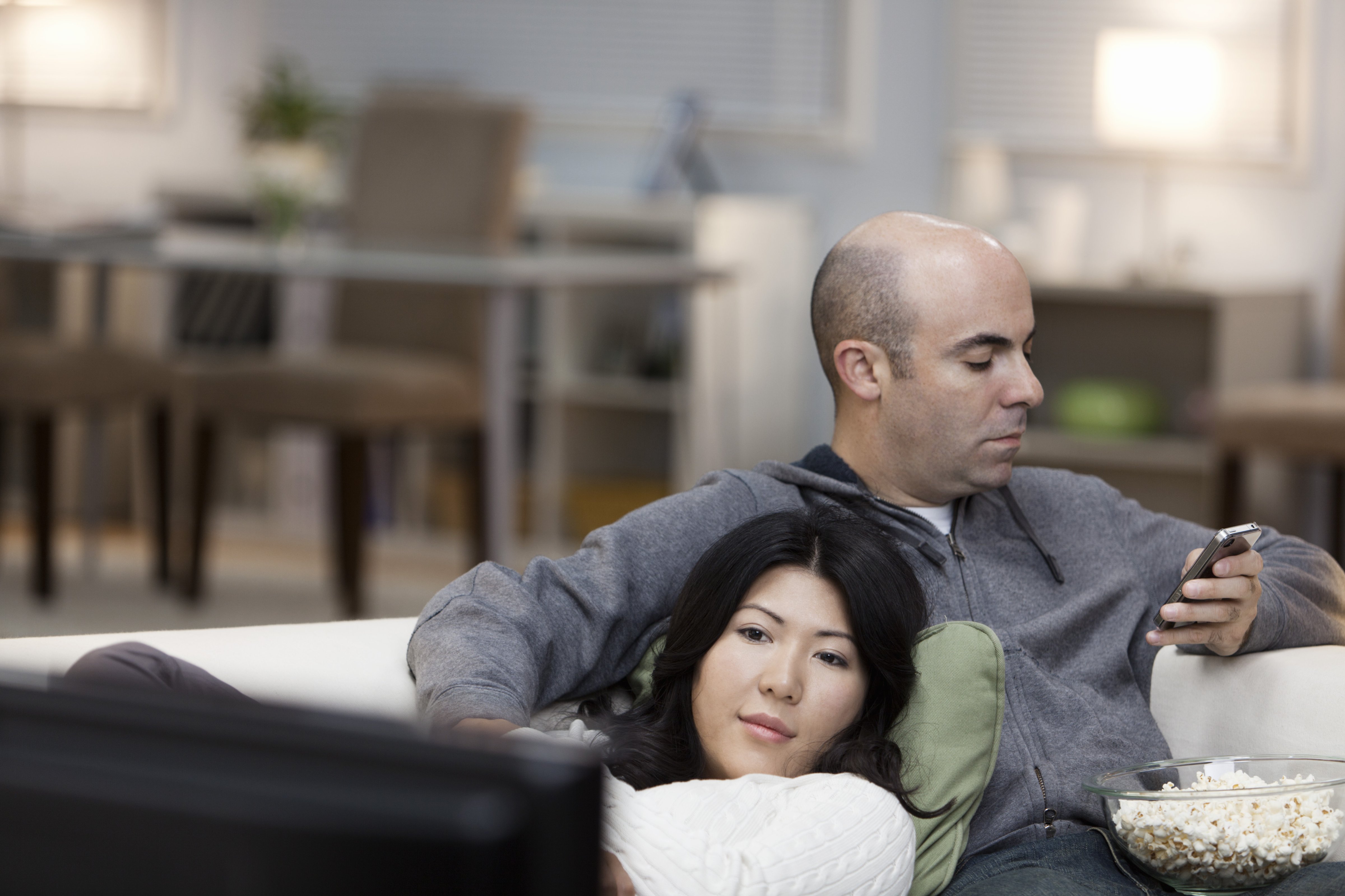 Couple on sofa watching television together