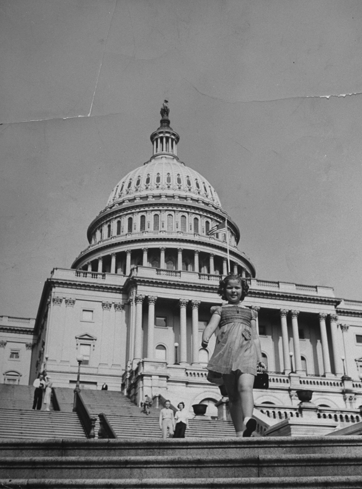 Shirley Temple walking on steps of the U.S. Capitol.
