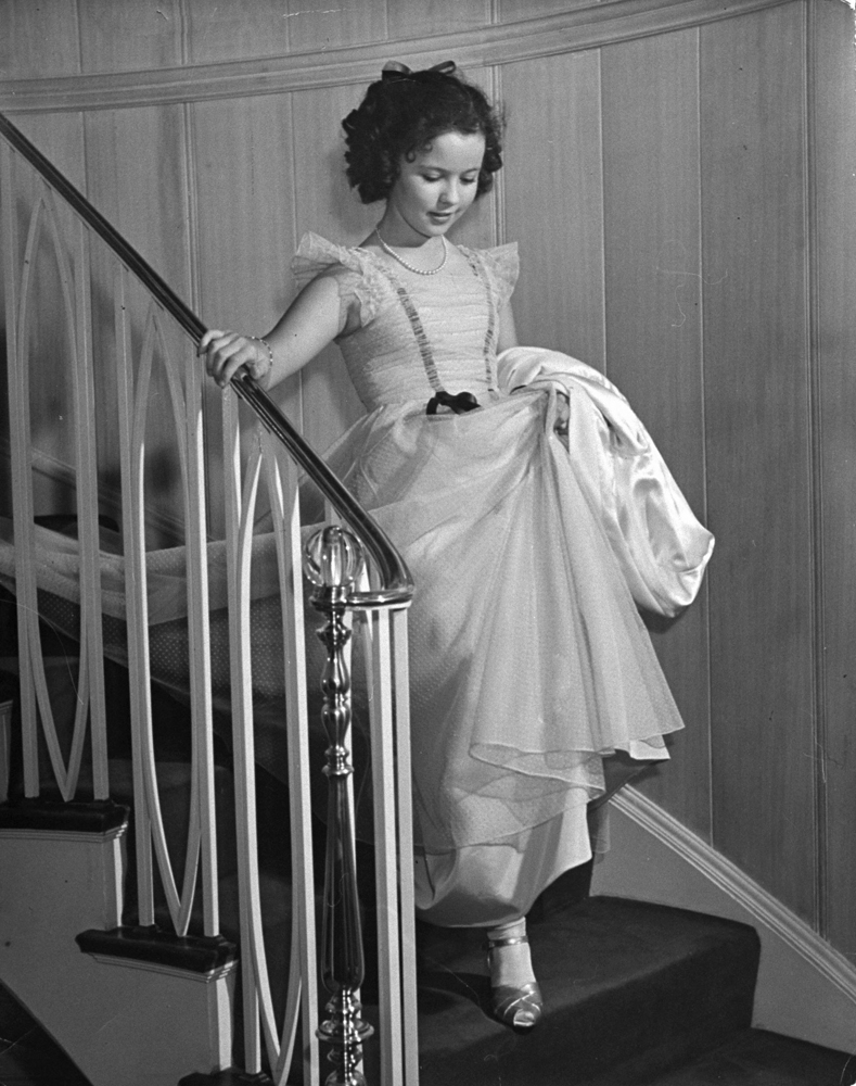 Shirley Temple walks down stairs at the Bel Air Country Club at her 11th birthday party, 1939.