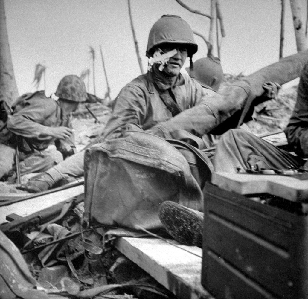 Caption from back of the print of this photograph in the LIFE archives: "Wounded Marine still fighting though his face is shot open, just after landing."