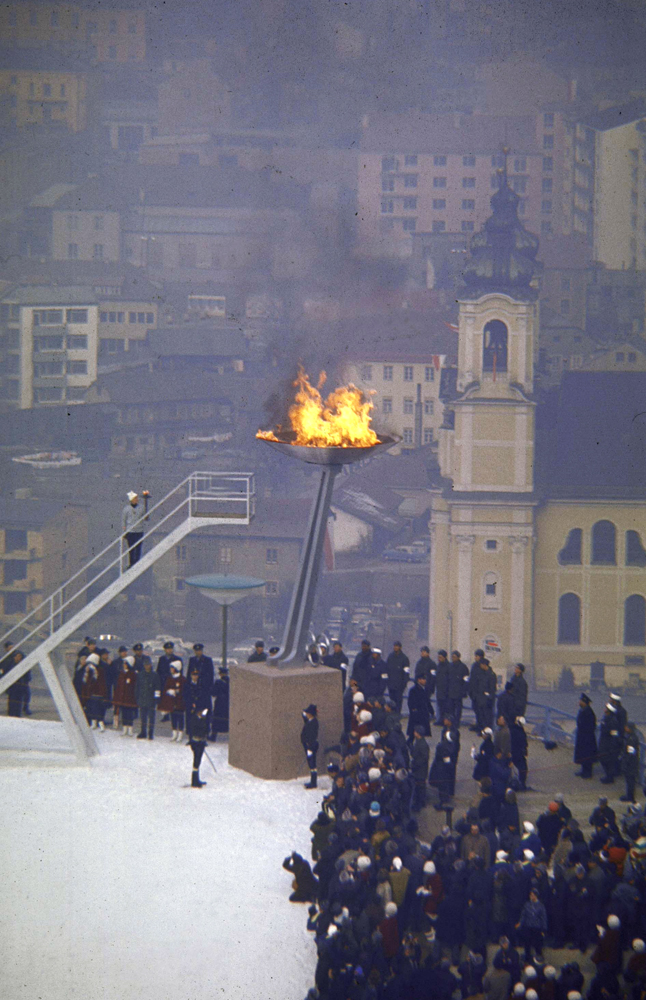 Austrian alpine skier Josl Rieder stands on stair having just lit the Olympic flame at the opening ceremonies of the 1964 Winter Olympics.
