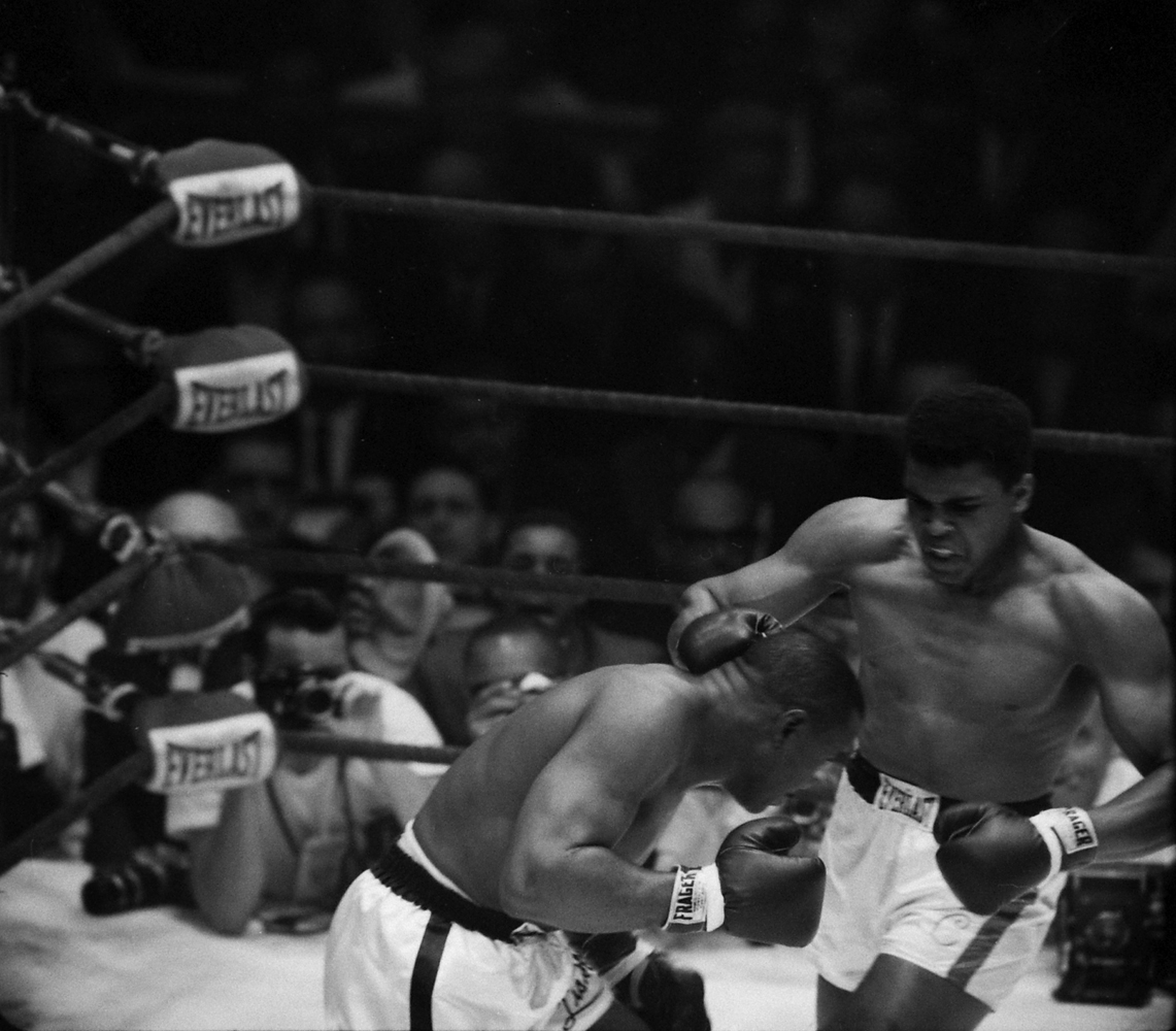 Cassius Clay pounds Sonny Liston's head during their first heavyweight title fight, Feb. 1964.