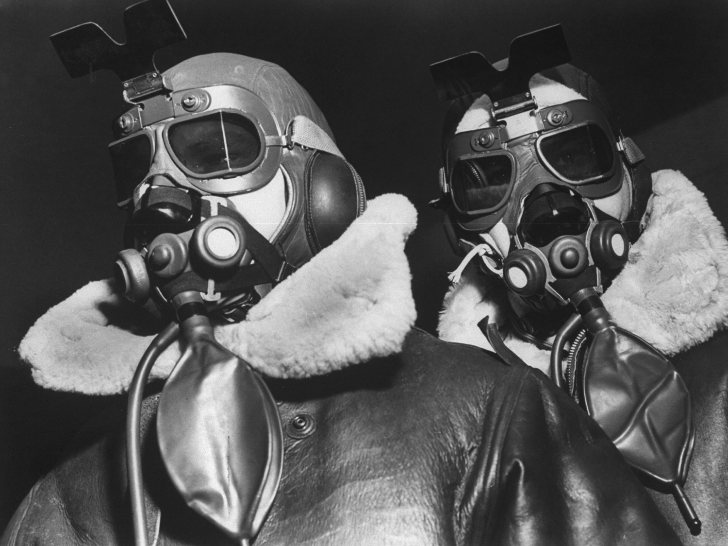 Two fliers of the VIII Bomber Command clad in high-altitude flying gear including sheepskin flight jackets, helmets, oxygen masks and goggles, 1942.