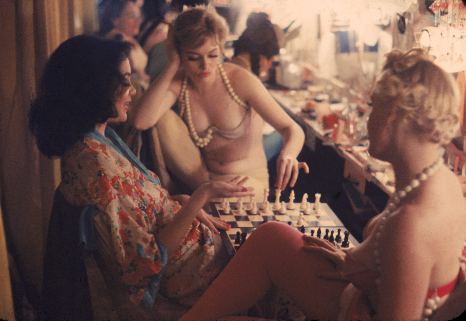 Between scenes in the show at New York's Latin Quarter, Pat Farrell prepares to make a chess move. Opponent (right) is Grace Sundstrom. Kibitzing at left is Shirley Forrest, an ex-schoolteacher.