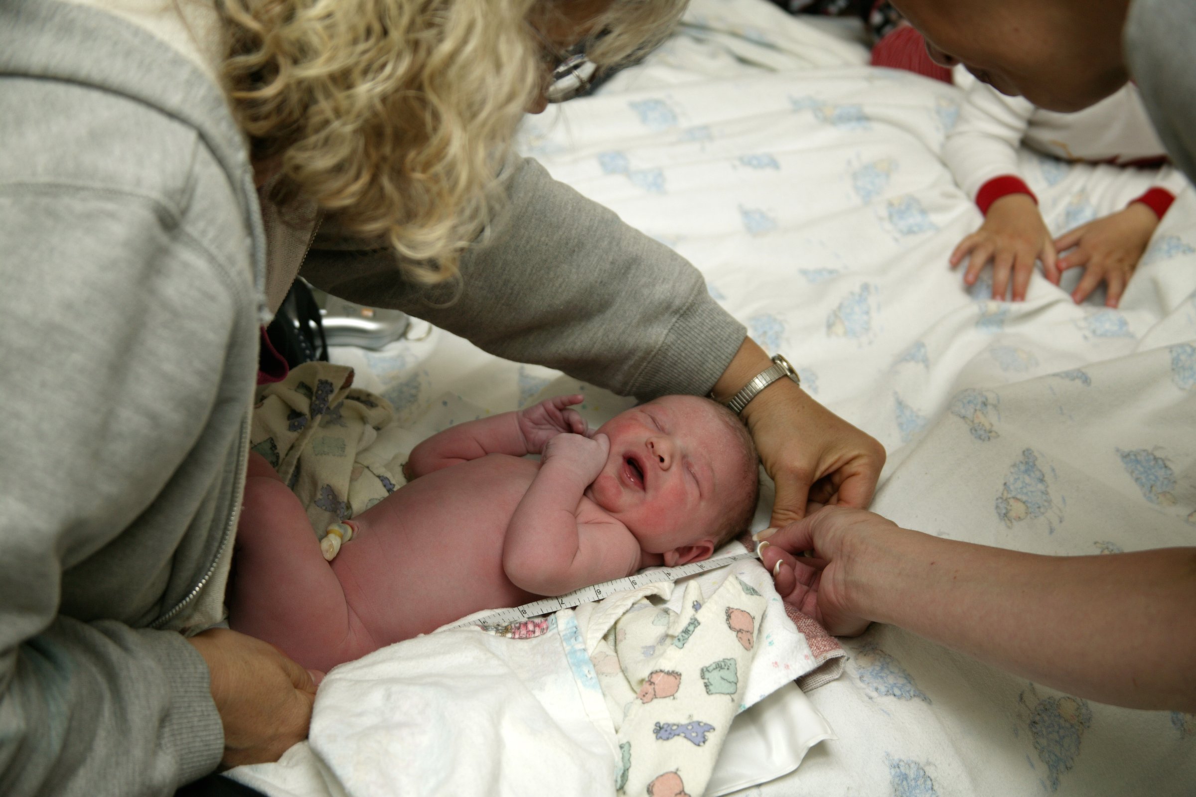 Home birth, Midwife measuring newborn