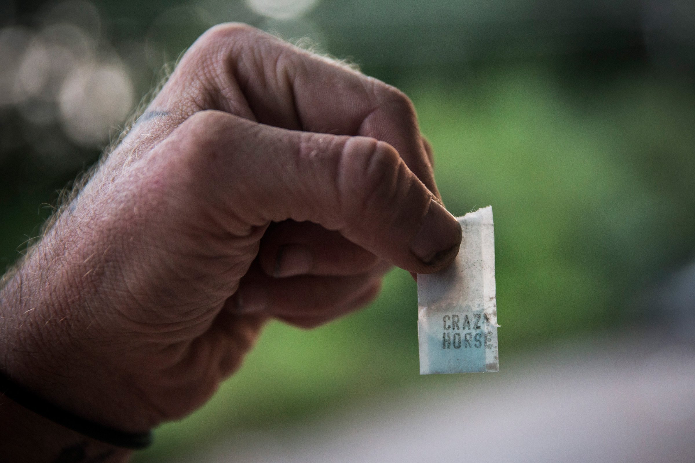 A man holds a bag of heroin labeled "Crazy Horse" in Camden, N.J., Aug. 21, 2013.